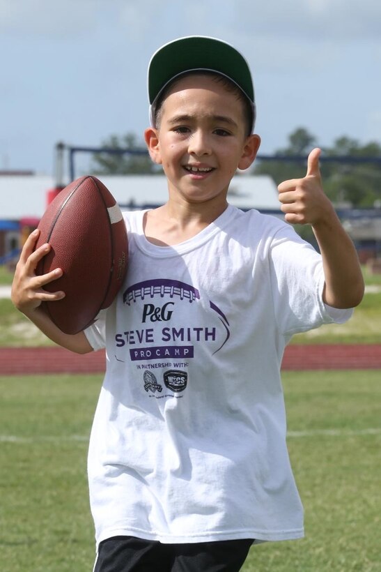 Markis B. is all smiles after catching a football during the Steve Smith ProCamp at Marine Corps Air Station Cherry Point, N.C., June 24, 2014. The installation was selected to host the camp for the second time after winning a contest between commissaries throughout the country.