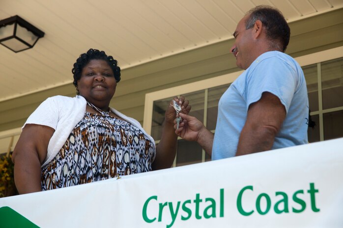 Dianne Brimmer-George accepts the keys to her new home from Leonard Farrugia, a volunteer with Habitat for Humanity in Newport, N.C., June 26, 2014.  Habitat for Humanity relied on donations and volunteers to complete the building of the house.