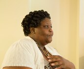 Dianne Brimmer-George, the recipient of a new home in Newport, N.C., waits with anticipation at the dedication ceremony for her new home June 26, 2014.  She and her family were grateful for the Marines and other volunteers for helping build their home.