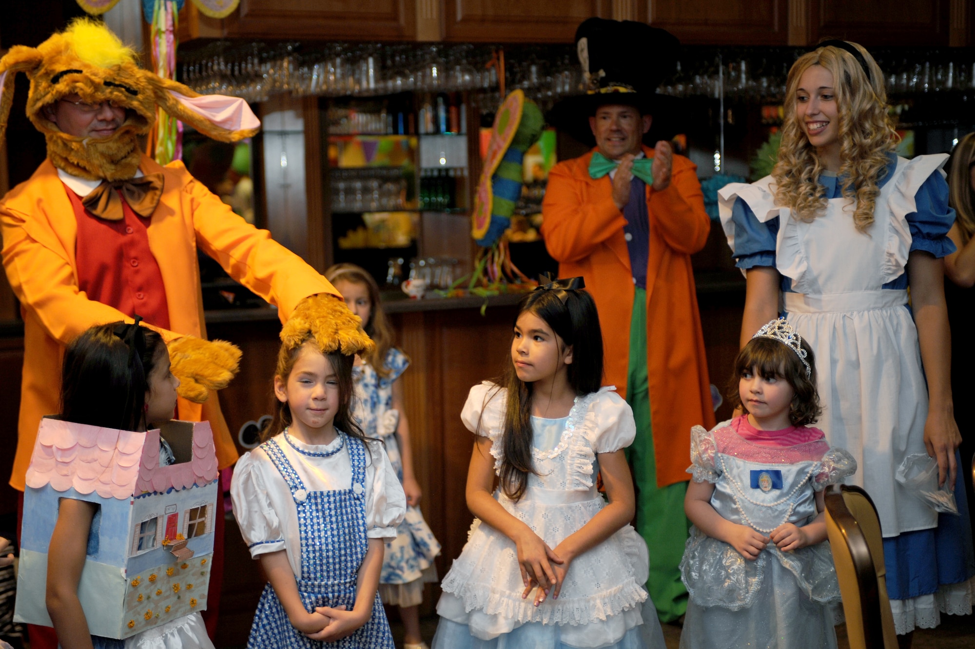 U.S. Air Force Capt. Joe Dowell  355th Force Support Squadron operations officer, chooses the best Alice costume during the “Meet Force Support Squadron Unbirthday Celebration” at Davis-Monthan Air Force Base, Ariz., June 26, 2014. Desert Lightning Team members were encouraged to come to the event dressed as an Alice in Wonderland Character in an effort to get the kids more involved and to win a prize. (U.S. Air Force photo by Airman 1st Class Cheyenne Morigeau/Released)
