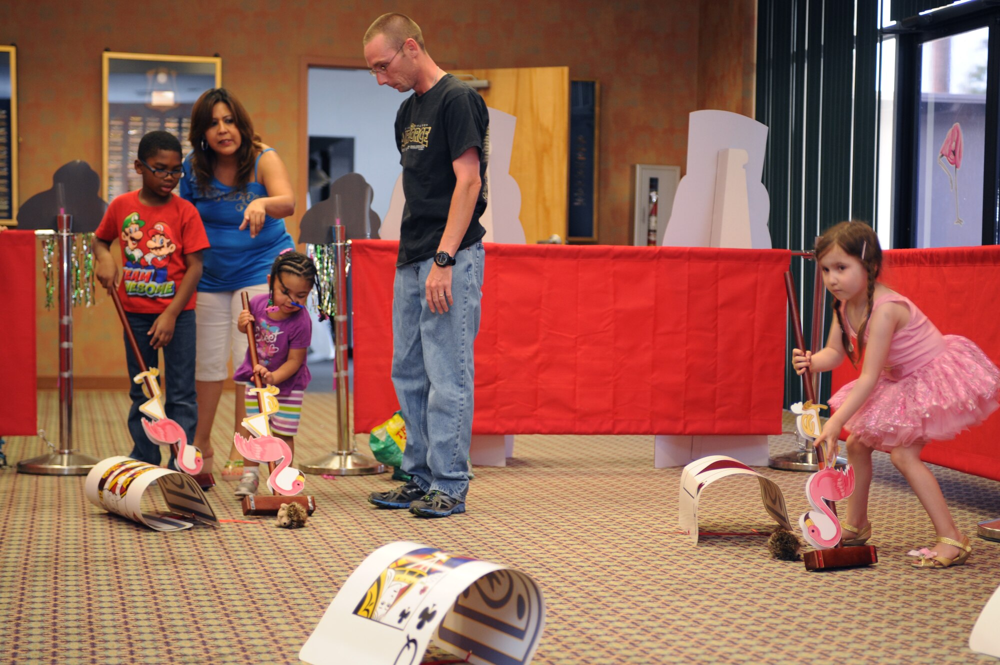 Desert Lightning Team members play a game of Royal Croquet during the “Meet Force Support Squadron Unbirthday Celebration” at Davis-Monthan Air Force Base, Ariz., June 26, 2014. There were different games for the DLT members to play while learning about each FSS facility. (U.S. Air Force photo by Airman 1st Class Cheyenne Morigeau/Released)