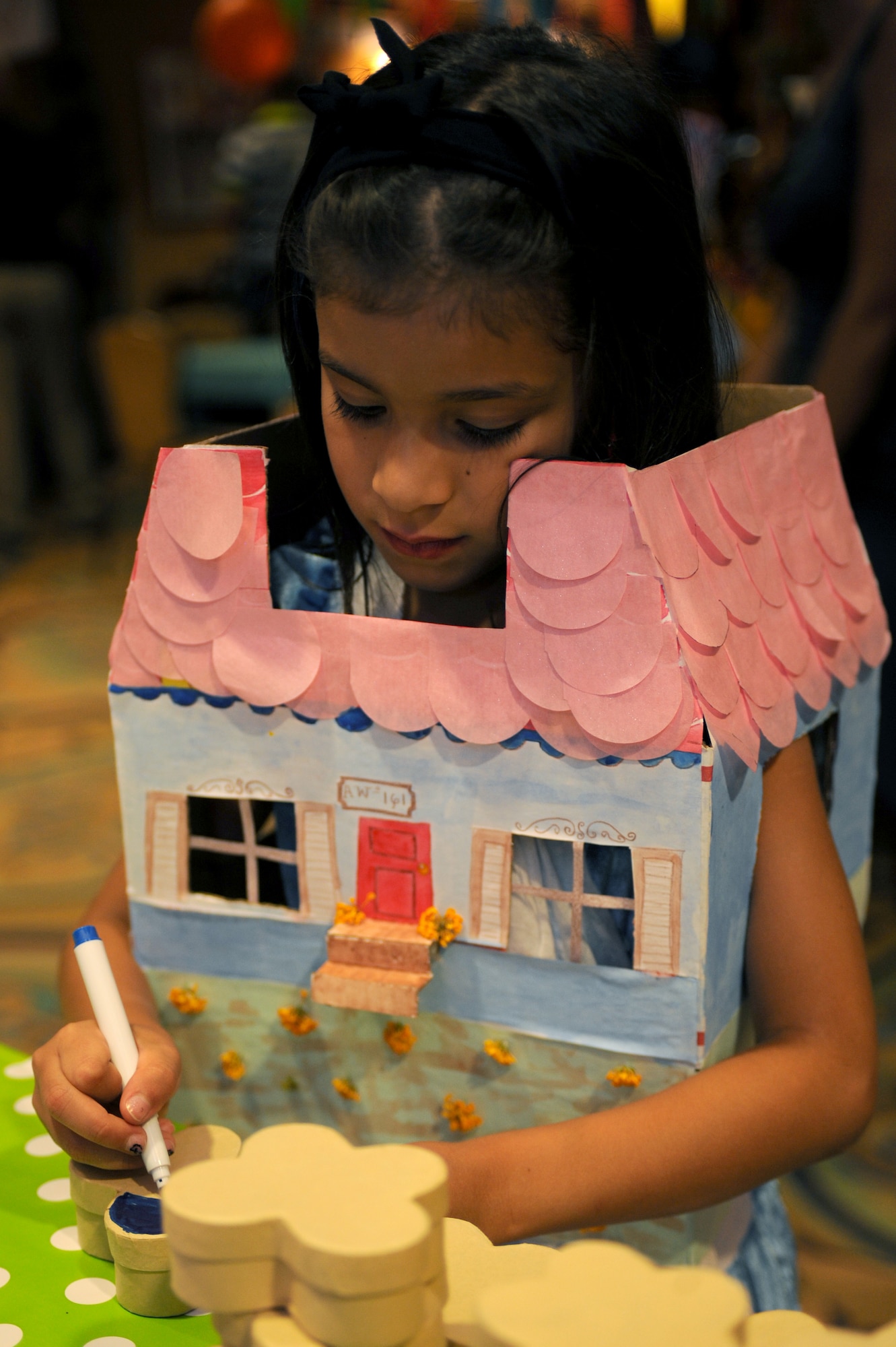 Ariana Lopez, daughter of U.S. Air Force TSgt. Edwin Lopez, 612th Air Communications Squadron NCO in charge of material control, colors a craft during the “Unbirthday Celebration” at Davis-Monthan Air Force Base, Ariz., June 26, 2014.The Alice in Wonderland themed event offered families a chance to hang out and learn about the different services provided by the 355th Force Support Squadron. (U.S. Air Force photo by Airman 1st Class Cheyenne Morigeau/Released)