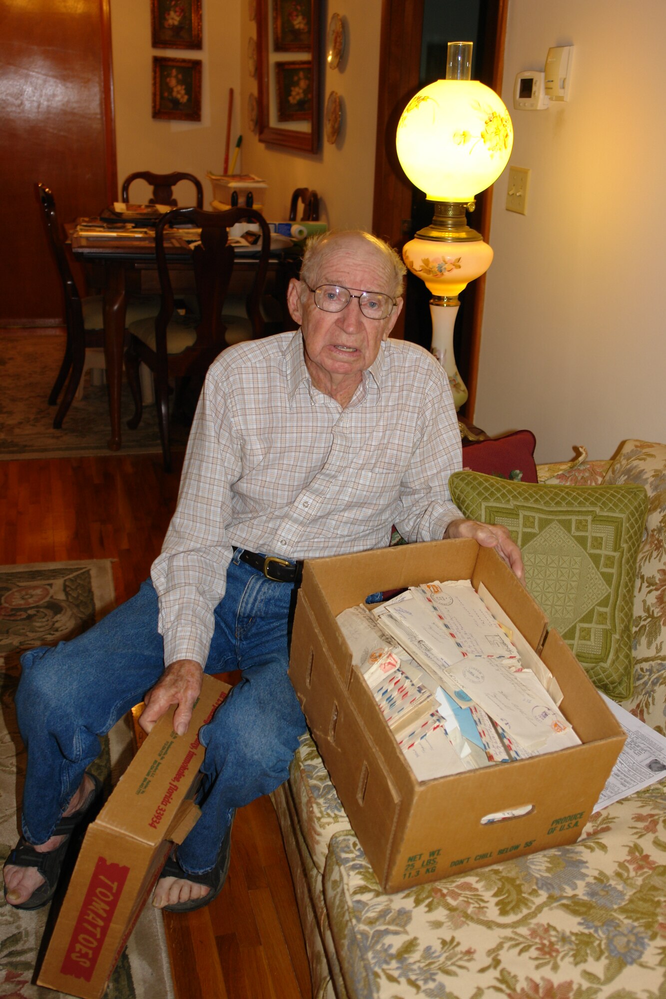 Joe Chadwell sent his wife Edith hundreds of letters while he served overseas during WWII. Pictured is Chadwell with the box of letters that Edith kept. (Photo by Deidre Ortiz)