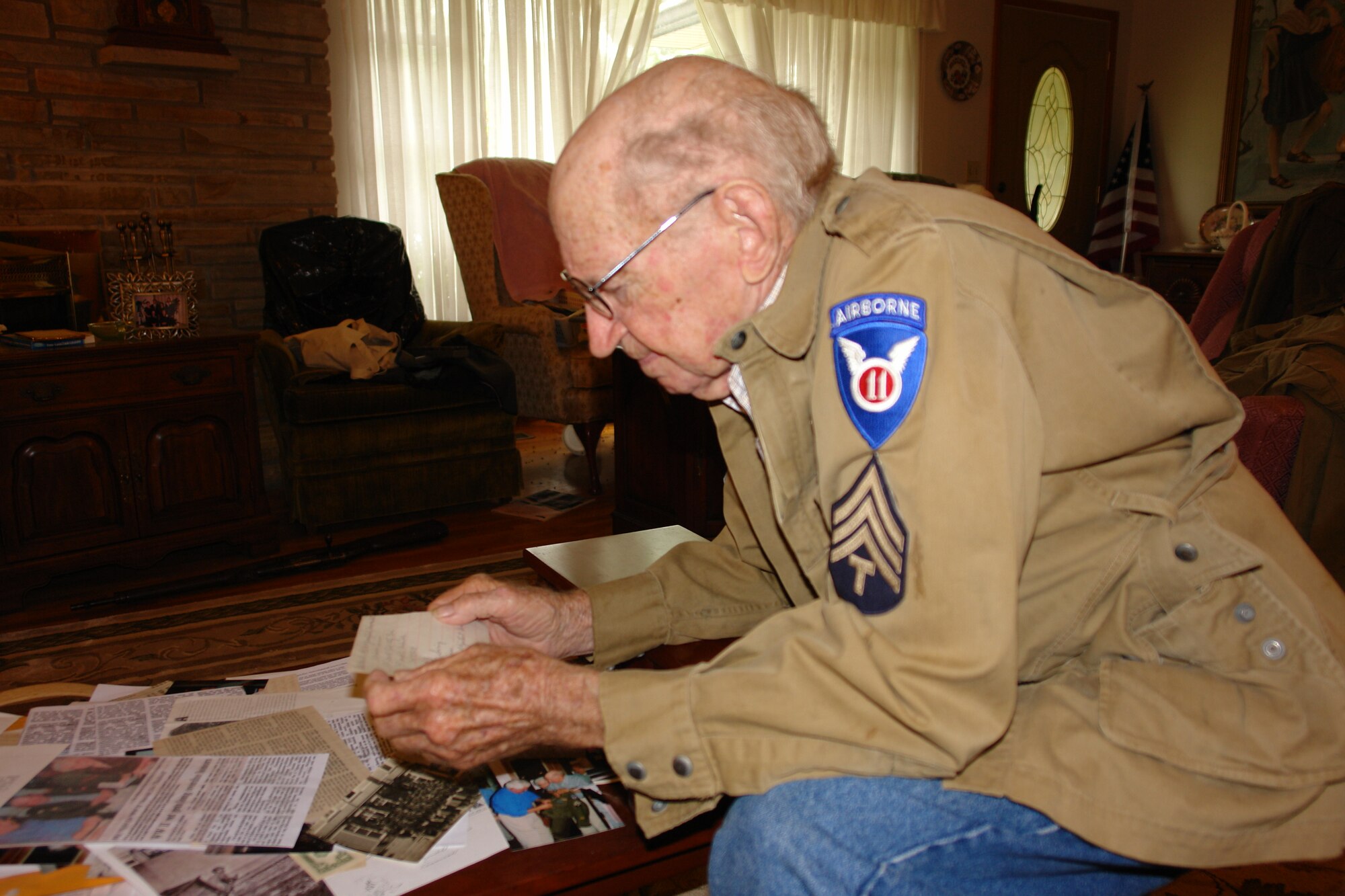 Looking through the different mementos he’s kept over the years, Joe Chadwell, AEDC retiree and WII veteran, takes a moment to read a note he received when he served in the U.S. Army’s 101st Airborne Division. (Photo by Deidre Ortiz)  