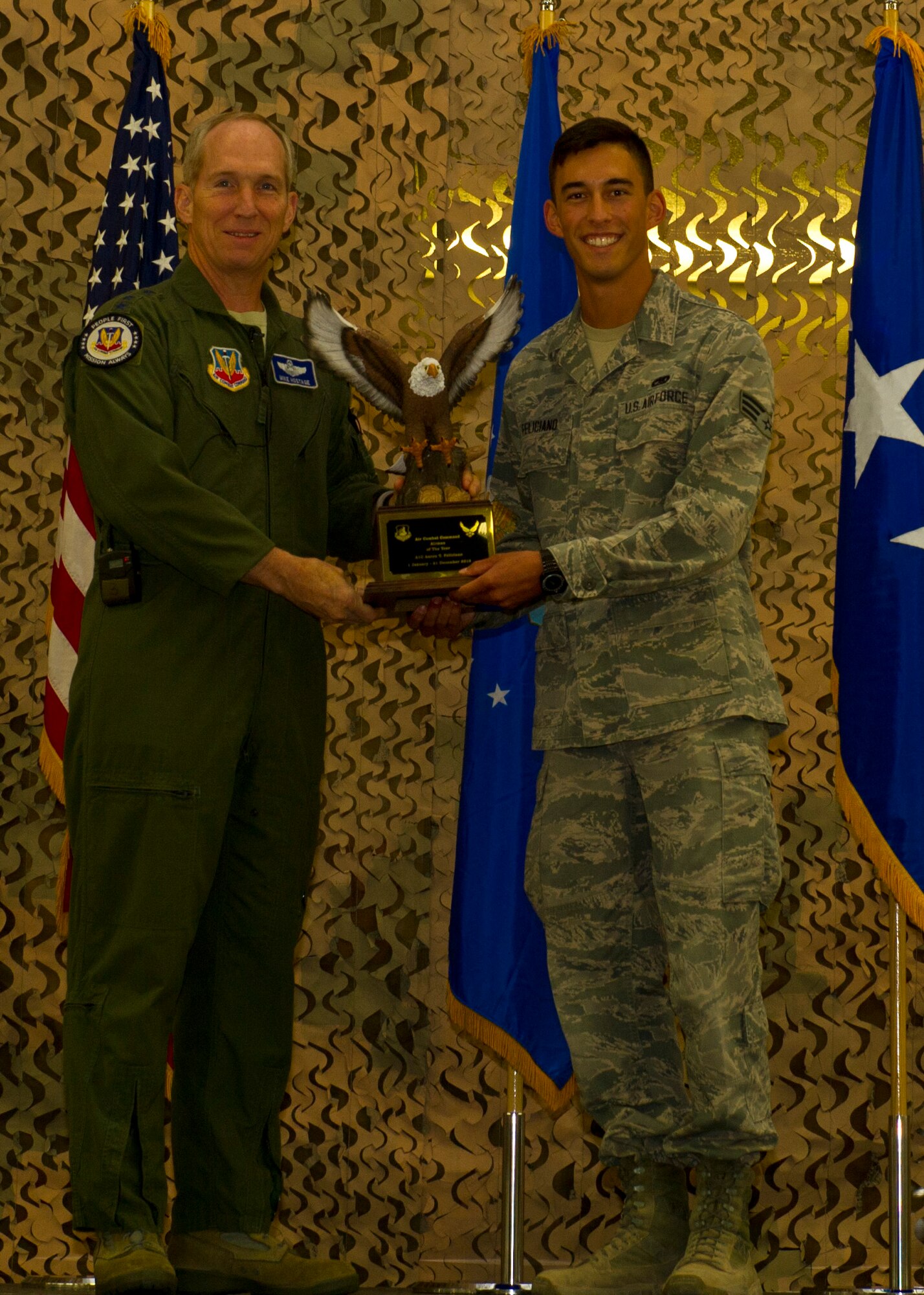 U.S. Air Force Gen. Mike Hostage, commander of Air Combat Command, presents Senior Airman Aaron Feliciano, 49th Aircraft Maintenance Squadron avionics technician, with the ACC Outstanding Airman of the Year Award, during his visit at Holloman Air Force Base, N.M., June 25.  Hostage visited Holloman to observe the mission and speak with Airmen of Team Holloman on important Air Force topics. (U.S. Air Force photo by Airman 1st Class Leah Ferrante/released) 