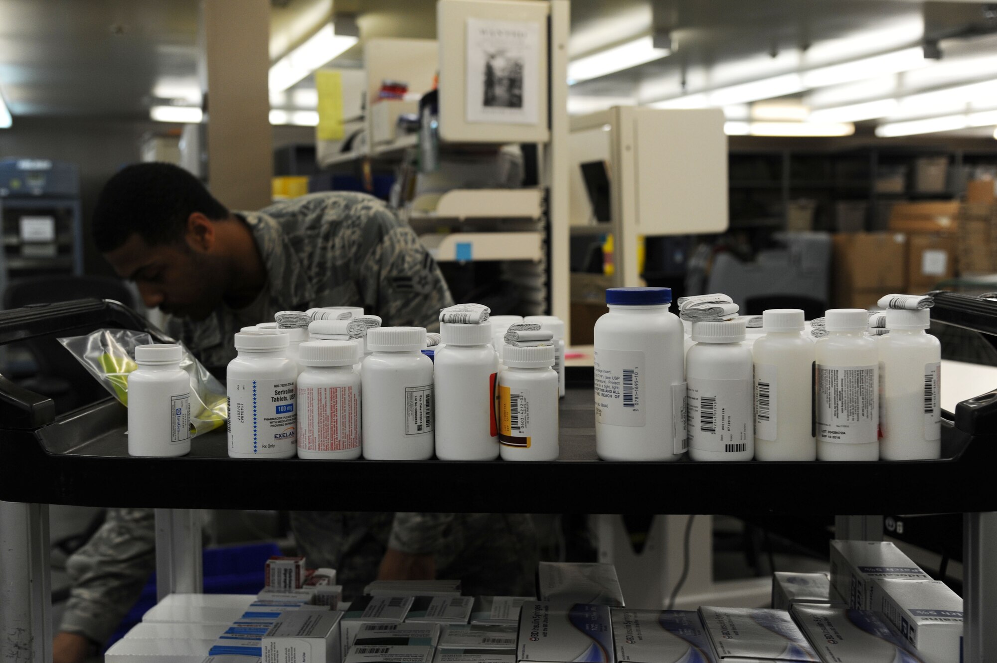 Airman 1st Class Quintin Lowe, 19th Medical Support Squadron medical material technician, places bottles of medication on a cart June 19, 2014, at Little Rock Air Force Base, Ark. Lowe organizes all medication before they are delivered to the pharmacy. (U.S. Air Force photo by Airman 1st Class Mercedes Muro)