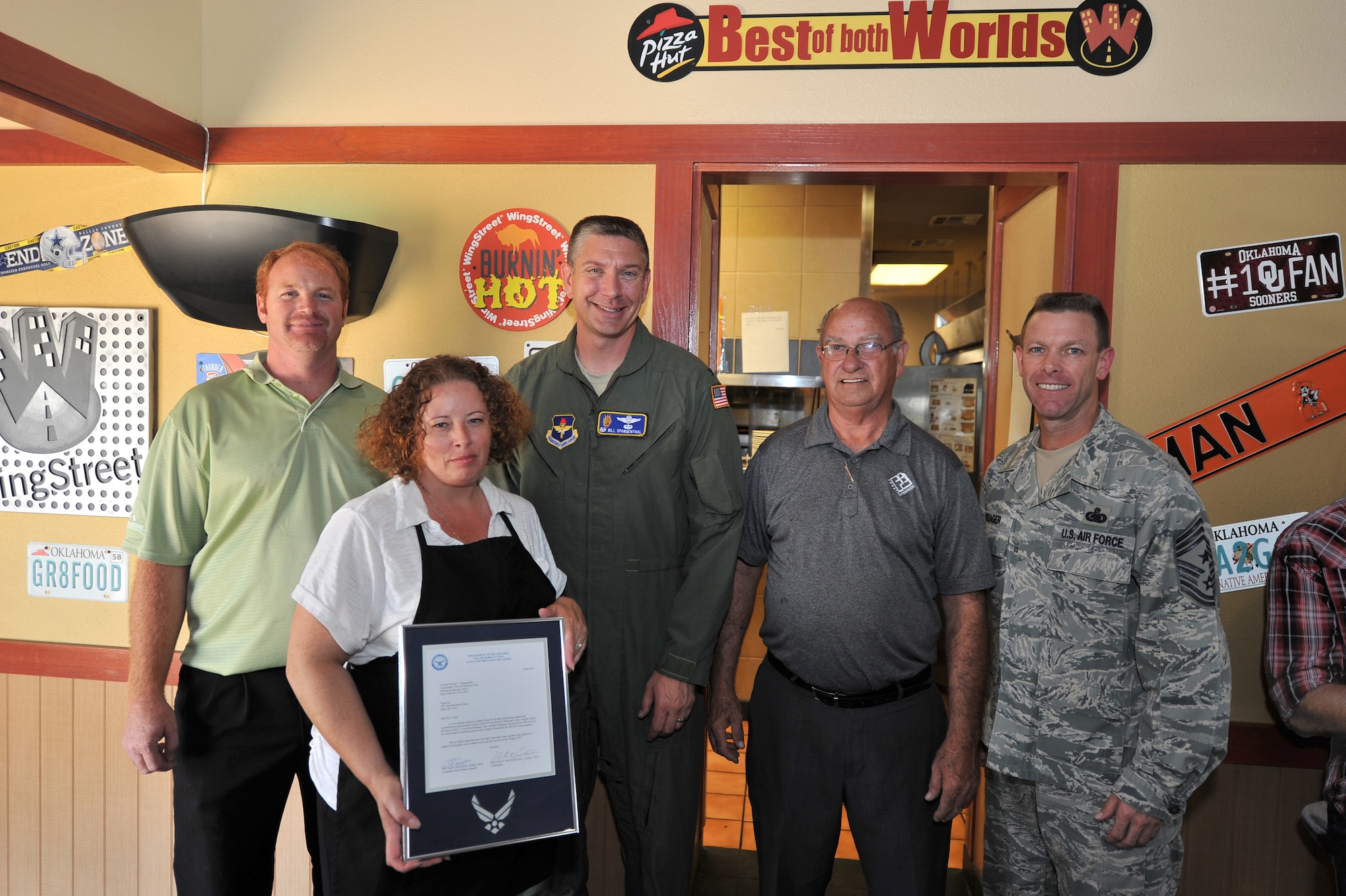ALTUS, Okla. – U.S. Air Force Col. Bill Spangenthal, 97th Air Mobility Wing commander, and U.S. Air Force Chief Master Sgt. Bryan Creager, 97th AMW command chief, present a letter of appreciation to (from left to right) Greg Chaffin, Jennifer Rodriquez and Paul Owens of Pizza Hut in Altus June 27, 2014. The letters of appreciation were presented to the members of Pizza Hut for donating pizzas to Airmen Against Drunk Driving volunteers. AADD is a program that provides a safe alternative for base members to help eliminate drinking and driving. (U.S. Air Force photo by Senior Airman Dillon Davis/Released)