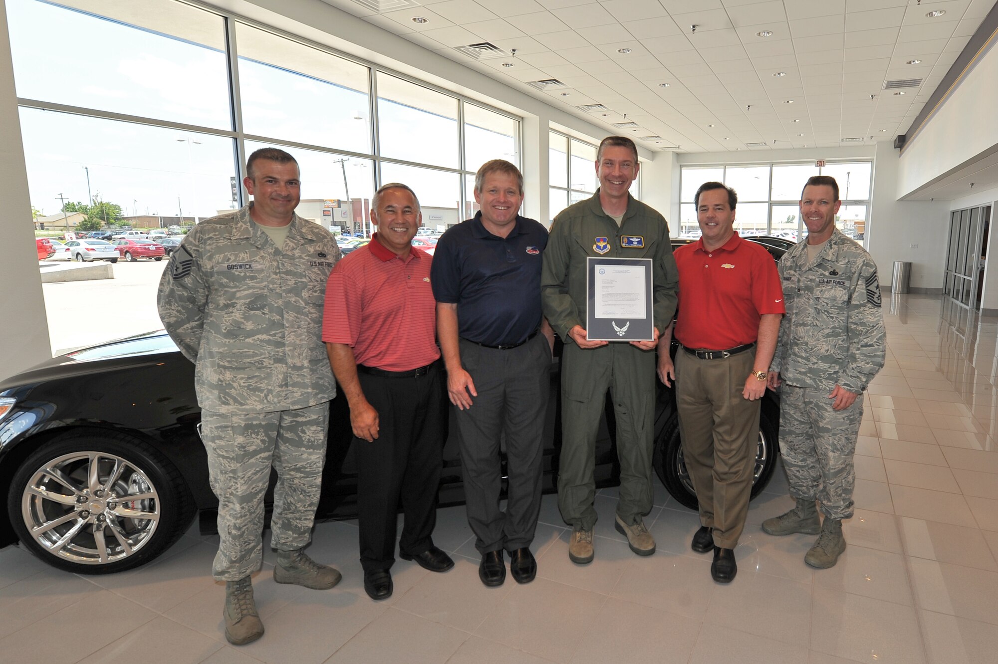 ALTUS, Okla. – U.S. Air Force Col. Bill Spangenthal, 97th Air Mobility Wing commander, and U.S. Air Force Chief Master Sgt. Bryan Creager, 97th AMW command chief, present a letter of appreciation to Tim Wilmes and Mike Elkins of Wilmes Chevrolet June 27, 2014. Wilmes Chevrolet was recognized for their help in maintaining the vehicles used by Airmen Against Drunk Driving. AADD is a program that provides a safe alternative for base members to help eliminate drinking and driving. (U.S. Air Force photo by Senior Airman Dillon Davis/Released)