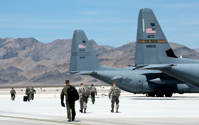 Aircrews of C-130H Hercules and C-130J Super Hercules step to their planes as they prepare to depart Creech Air Force Base, Nev., June 22, 2014.  Twelve C-130H and C-130J model aircraft participated in Joint Forcible Entry, an exercise designed to enhance service cohesiveness between the U.S. Army and Air Force. Both services work together to properly execute large scale heavy equipment and troop movement. (U.S. Air Force photo by Senior Master Sgt. Cecilio Ricardo/Released)
