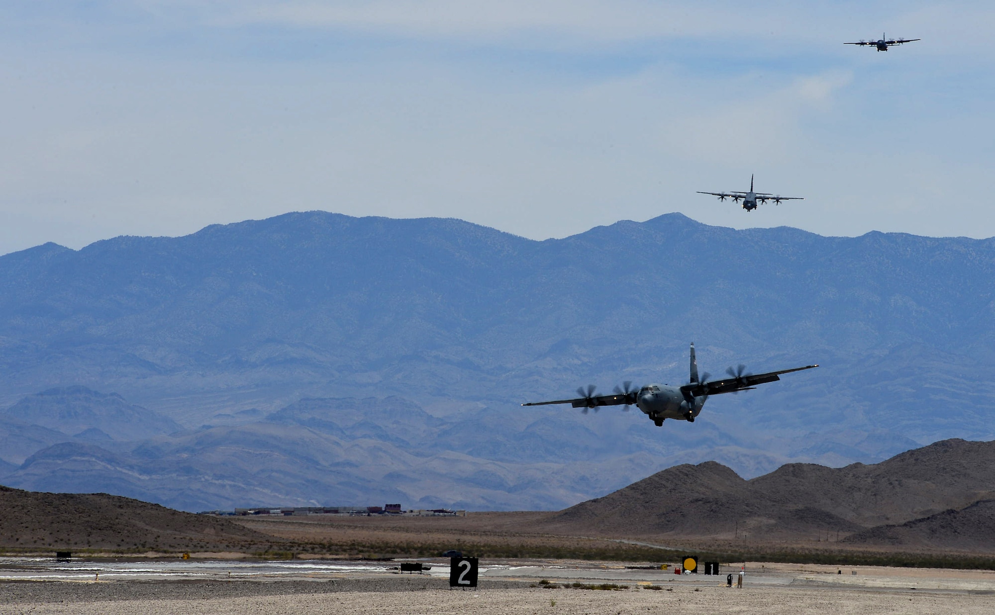 C-130J Super Hercules aircraft prepare to land at Creech Air Force Base, Nev., during Joint Forcible Entry June 21, 2014. The joint airdrop exercise is designed to enhance service cohesiveness between the U.S. Army and Air Force. It gives both services an opportunity to properly execute large scale heavy equipment and troop movement. (U.S. Air Force photo by Tech. Sgt. Nadine Barclay/Released)

