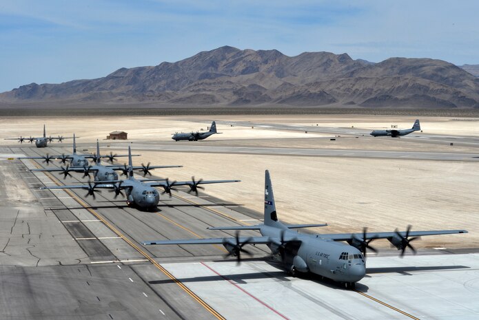 Seven C-130J Super Hercules aircraft taxi after landing at Creech Air Force Base, Nev., as part of Joint Forcible Entry exercise June 21, 2014. The aircraft were used to help Airmen and Soldiers from Nellis Air Force Base, Nev., and visiting units enhance service cohesiveness while allowing the opportunity to properly execute large scale heavy equipment and troop movement. (U.S. Air Force photo by 1st Lt. Stephani Schafer/Released)