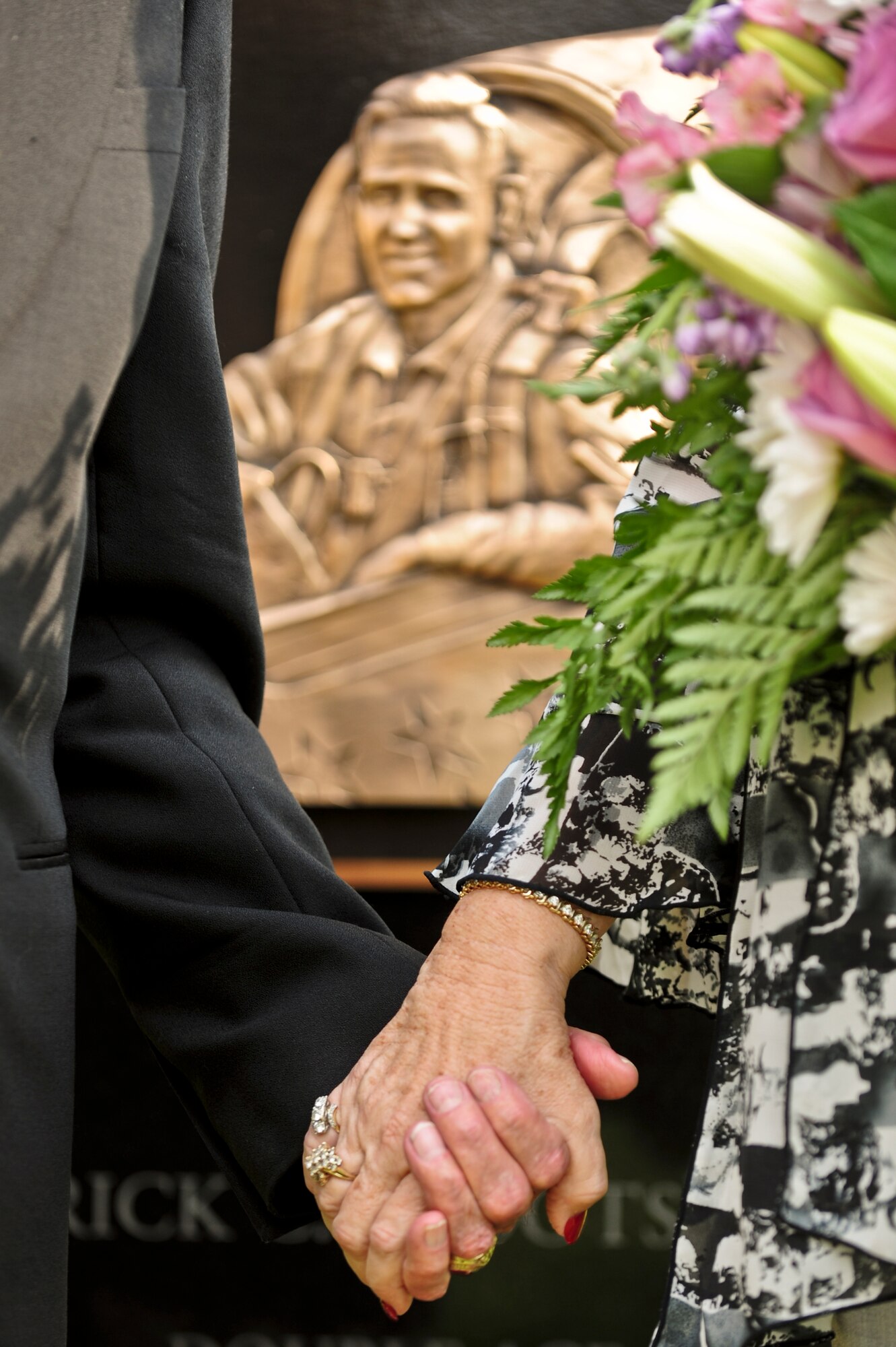 Betty Blesse, wife of late Maj. Gen. Frederick “Boots” Blesse, and retired Lt. Gen. Charles Cleveland hold hands during a memorial dedication ceremony to honor “Boots”, June 27, 2014, at Seymour Johnson Air Force Base, North Carolina.  Betty, as well as hundreds of family members, friends and fellow squadron members, gathered for the ceremony.  (U.S. Air Force photo/Airman 1st Class Brittain Crolley)