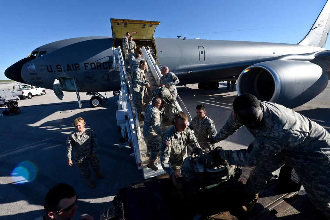 Members of the North Carolina National Guard 105th Military Police Battalion loads luggage into a KC-135 Stratotanker at Ellsworth Air Force Base, S.D., June 20, 2014 as part of the Golden coyote exercise. Golden Coyote tests the ability of engineering and support units to mobilize equipment, deploy to a battle zone, coordinate combat and service support missions, and re-deploy back to home station. (U.S. Air Force photo by Senior Airman Zachary Hada/Released)