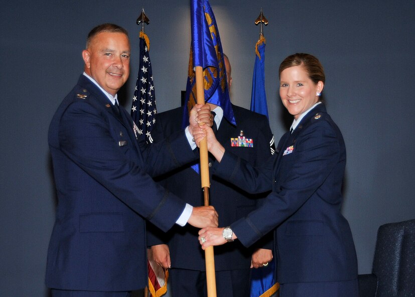 Colonel Frederick Weaver, 325th Medical Group commander, passes the 325th Medical Operations Squadron guidon to Lt. Col. Michelle Montgomery who assumed command of the 325th MDOS in a change of command ceremony June 27. (U.S. Air Force photo by Airman 1st Class Sergio Gamboa)