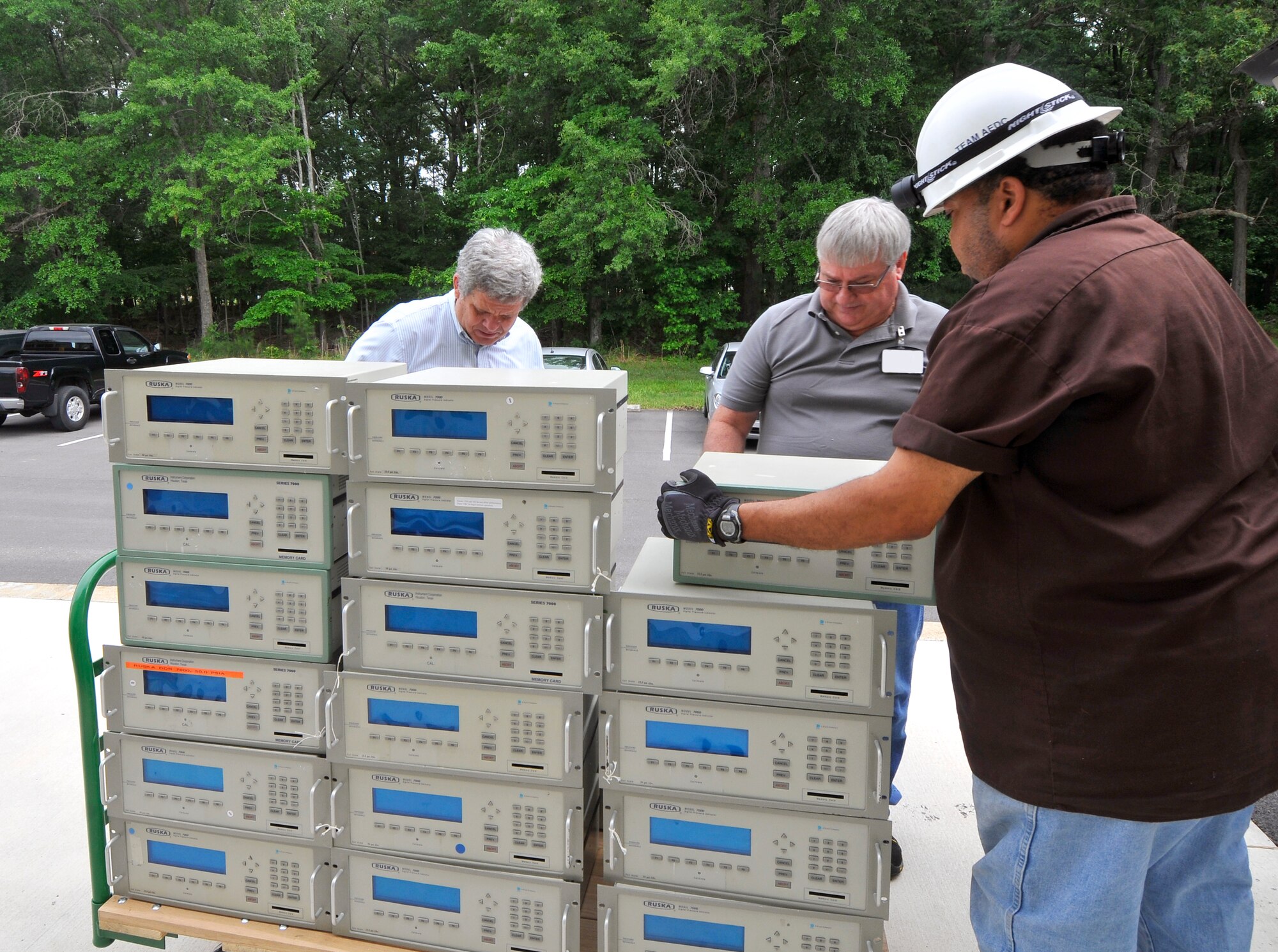 Aerospace Testing Alliance (ATA) Information Technology and Systems Department personnel Maynard Schewe (center) and Mike Williams (right) assist Joel Davenport (left), associate director of Technical Research Support Group at the University of Tennessee Space Institute, in loading the pressure measurement equipment donated to UTSI. (Photo by Jacqueline Cowan)