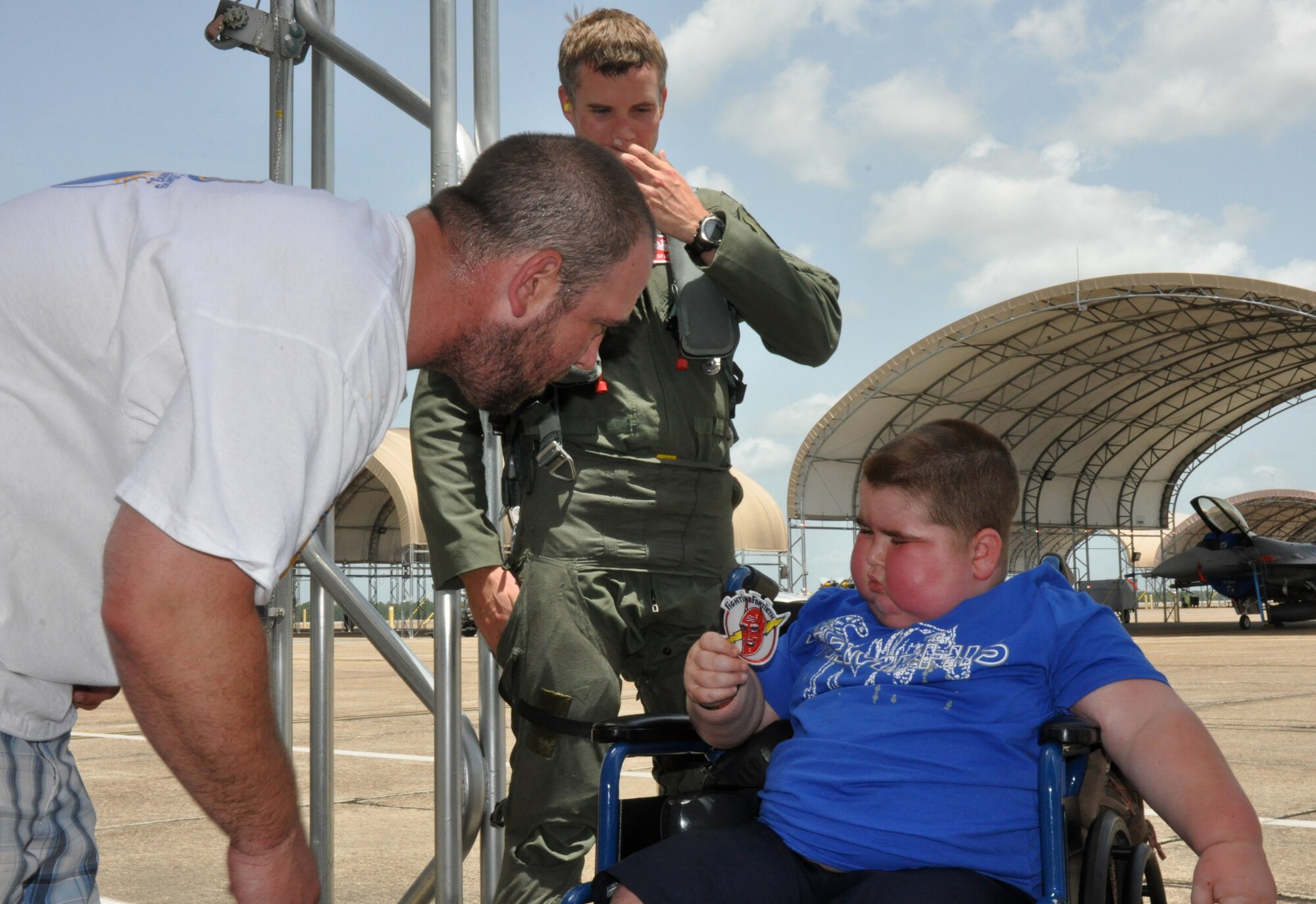Special guest Derek Vincent, 6, shows his father Jeff Vincent, the 40th Flight Squadron patch he received from a pilot while on tour with the 96th Aircraft Maintenance Squadron June 27. Vincent was diagnosed with a brain tumor in January and recently battled six weeks of radiation unsuccessfully in Memphis, Tenn. To show support to their Airman who is a long-time family friend of the boy from his hometown, the 96th AMXS let Vincent spend two hours on the job with them. (U.S. Air Force photo/Chrissy Cuttita)