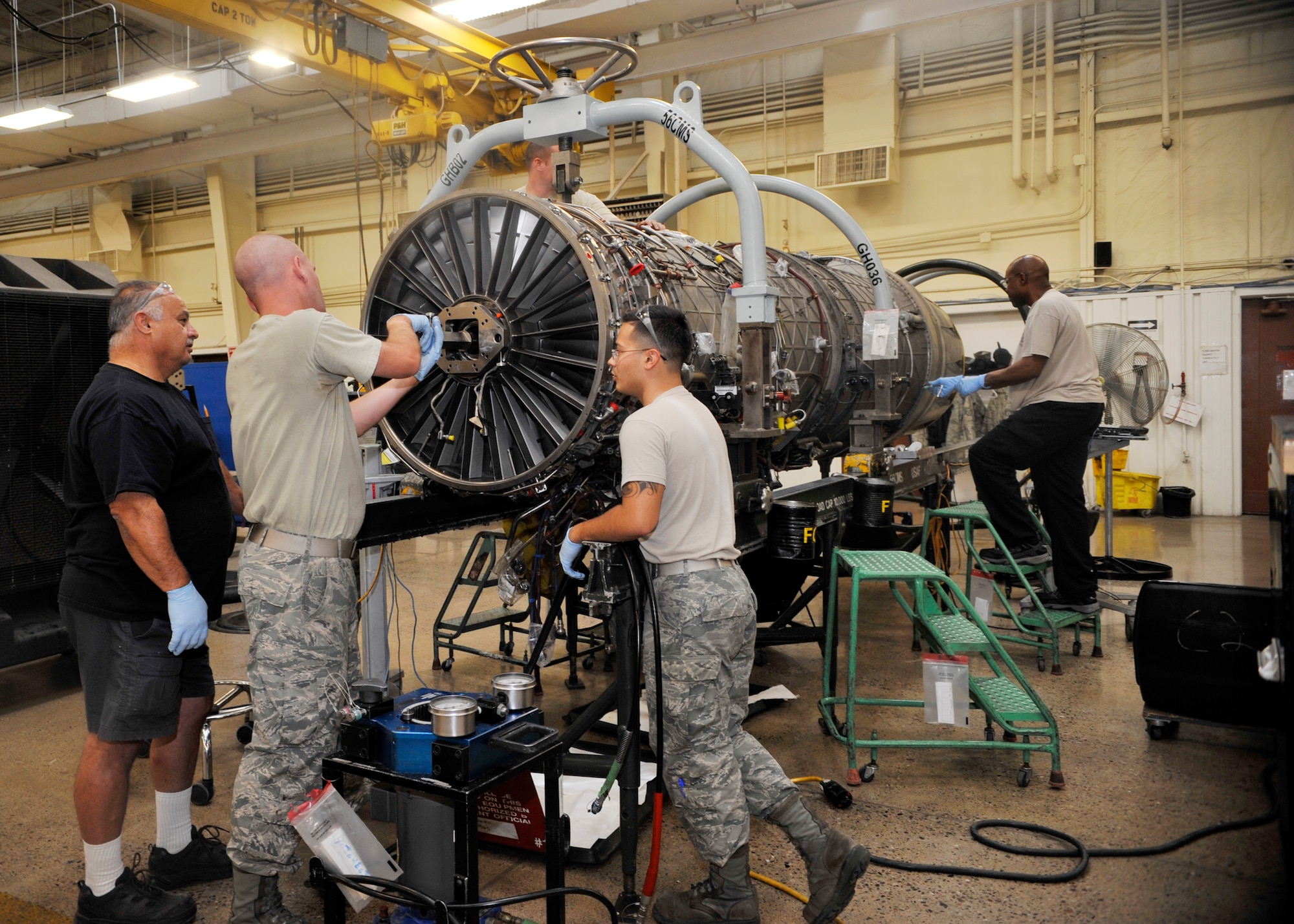 Airmen of the 56th Component Maintenance Squadron Jet Engine Intermediate Maintenance Flight work on an F-16 Fighting Falcon F100-220 engine June 17 on Luke Air Force Base. These Airmen are responsible for engine servicing, repairing and inspection. The F-16 F100-220 engine is 191.15 inches in length, weighs 3,218 pounds, has a diameter of 44.60 inches and a max fuel flow of 49,964 pounds per hour. (U.S. Air Force photo/Senior Airman Marcy Copeland)