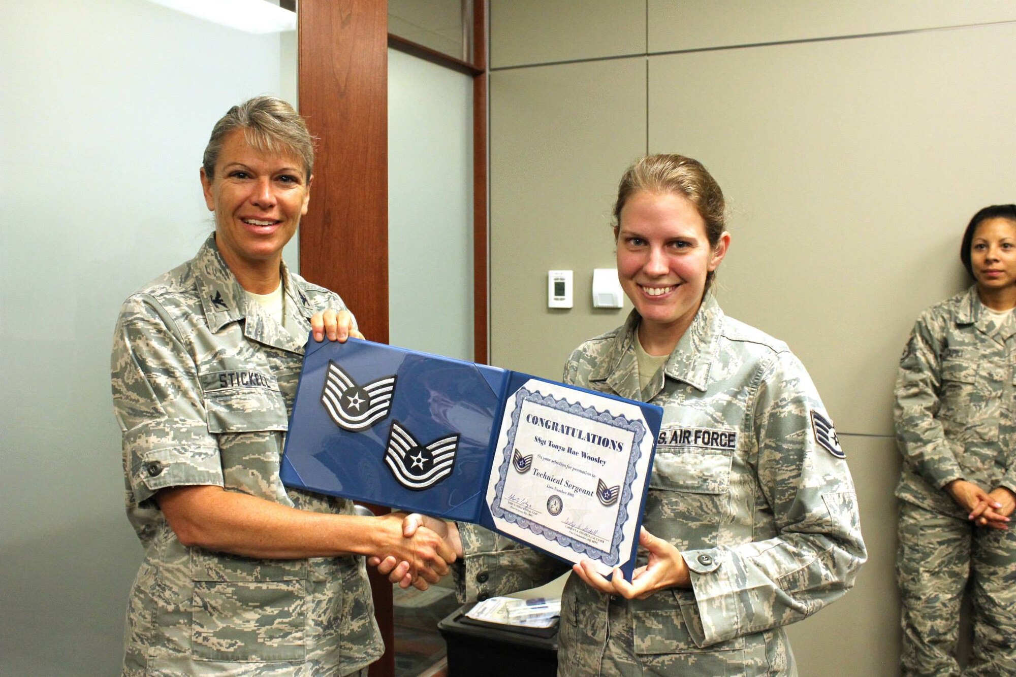 Staff Sgt. Tonya Woosley accepts a certificate of congratulations for making technical sergeant from Col. Carolyn Stickell, individual mobilization augmentee to the vice commander, Air Reserve Personnel Center, June 26. Six active duty Airmen and one guardsman were honored, June 26, for making promotion while serving at Buckley Air Force Base, Colo. (U.S. Air Force photo/Master Sgt. Christian Michael) 