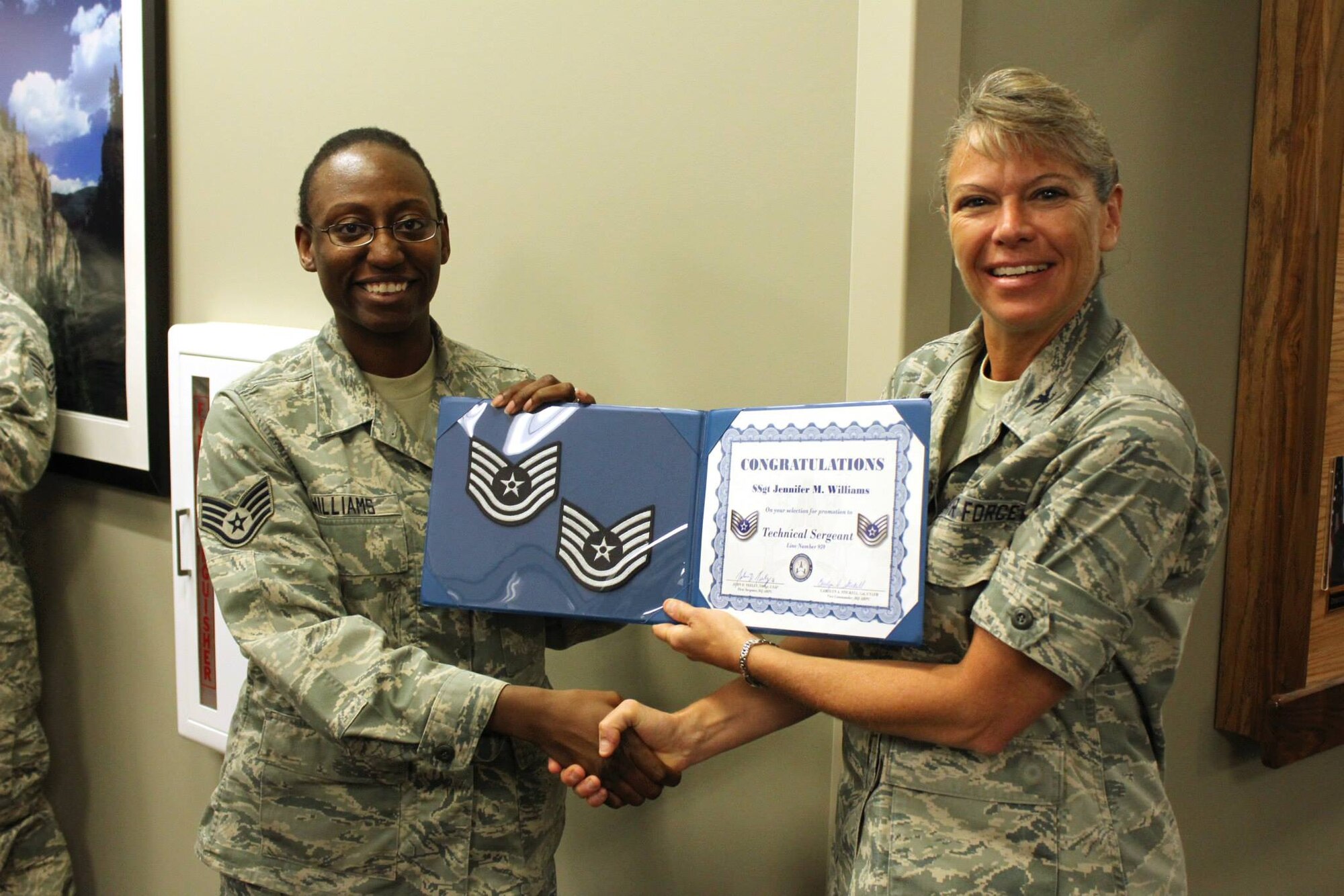 Staff Sgt. Jennifer Williams accepts a certificate of congratulations for making technical sergeant from Col. Carolyn Stickell, individual mobilization augmentee to the vice commander, Air Reserve Personnel Center, June 26. Six active duty Airmen and one guardsman were honored, June 26, for making promotion while serving at Buckley Air Force Base, Colo. (U.S. Air Force photo/Master Sgt. Christian Michael)
