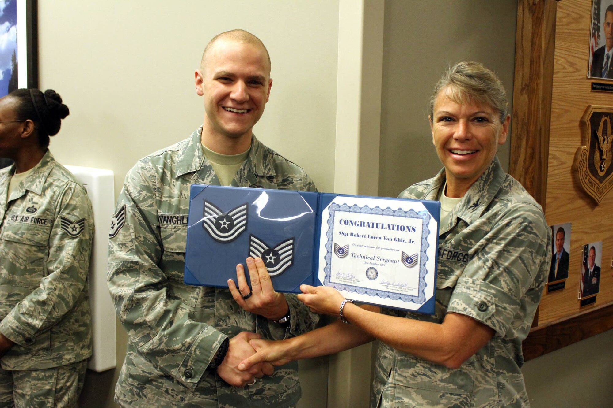 Staff Sgt. Robert Van Ghle, Jr., accepts a certificate of congratulations for making technical sergeant from Col. Carolyn Stickell, individual mobilization augmentee to the vice commander, Air Reserve Personnel Center, June 26. Six active duty Airmen and one guardsman were honored, June 26, for making promotion while serving at Buckley Air Force Base, Colo. (U.S. Air Force photo/Master Sgt. Christian Michael)