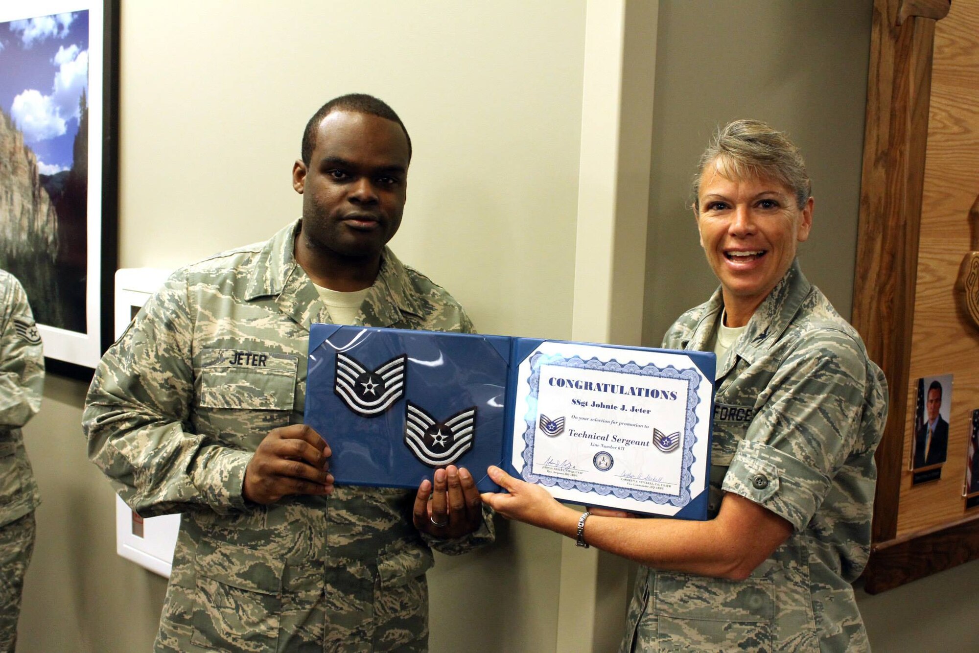 Staff Sgt. Johnte Jeter accepts a certificate of congratulations for making technical sergeant from Col. Carolyn Stickell, individual mobilization augmentee to the vice commander, Air Reserve Personnel Center, June 26. Six active duty Airmen and one guardsman were honored, June 26, for making promotion while serving at Buckley Air Force Base, Colo. (U.S. Air Force photo/Master Sgt. Christian Michael) 