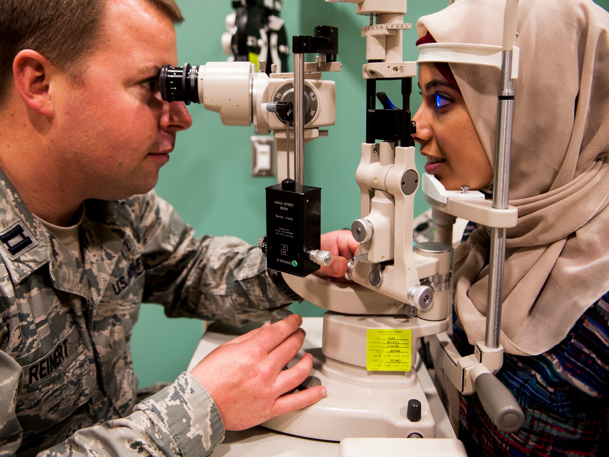 Capt. Richard Reinert, 30th Medical Operations Squadron optometry element chief, simulates an eye exam with Fatima Elktabi, optometry intern, June 27, 2014, Vandenberg Air Force Base, Calif. The small team of optometrists and technicians at Vandenberg are a vital part of the health and well-being of service members and their families. Overseeing more than 4,600 patients a year, the unit stays busy. (U.S. Air Force photo by Airman 1st Class Yvonne Morales/Released)
