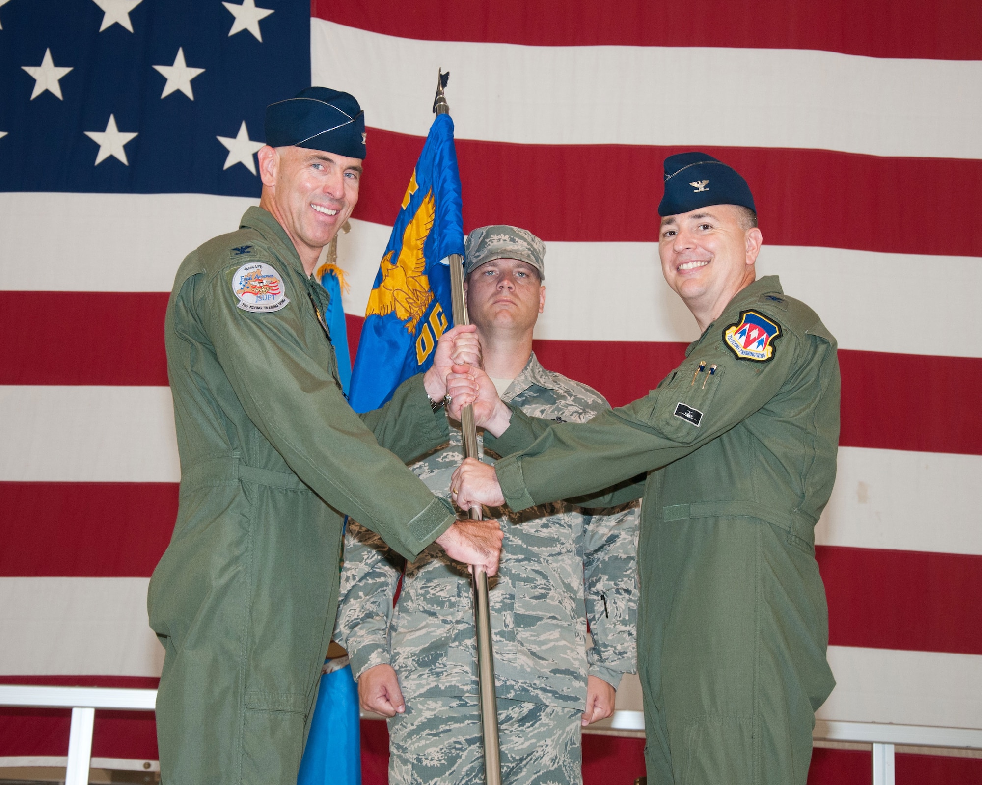 VANCE AIR FORCE BASE, Okla. – From right to left, Col. John D. Cinnamon accepts the 71st Operations Group guidon from Col. Clark Quinn June 26 in Hangar 199. Cinnamon assumed command from Col. James Abatti who is headed to Randolph Air Force Base, Texas. Cinnamon is a command pilot with 4,200 hours in the T-1, T-3, T-38 and C-5 Galaxy. (U.S. Air Force photo/Terry Wasson) 
