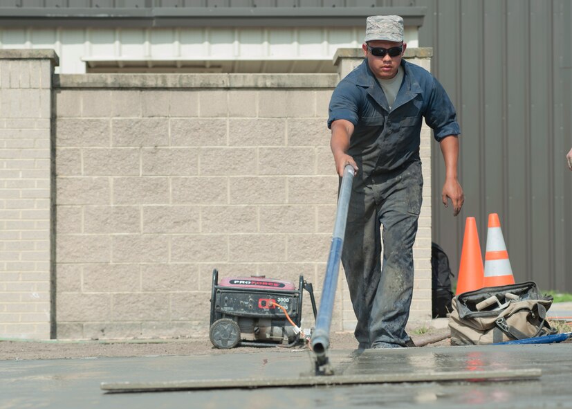 Staff Sgt. Cesar Salas, 436th Civil Engineer Squadron payment and equipment operator, levels a large section of concrete June 25, 2014, on Dover Air Force Base, Del. The concrete poured that day was part of a larger project to upgrade the shooting range’s capability. (U.S. Air Force photo/Senior Airman Jared Duhon) 