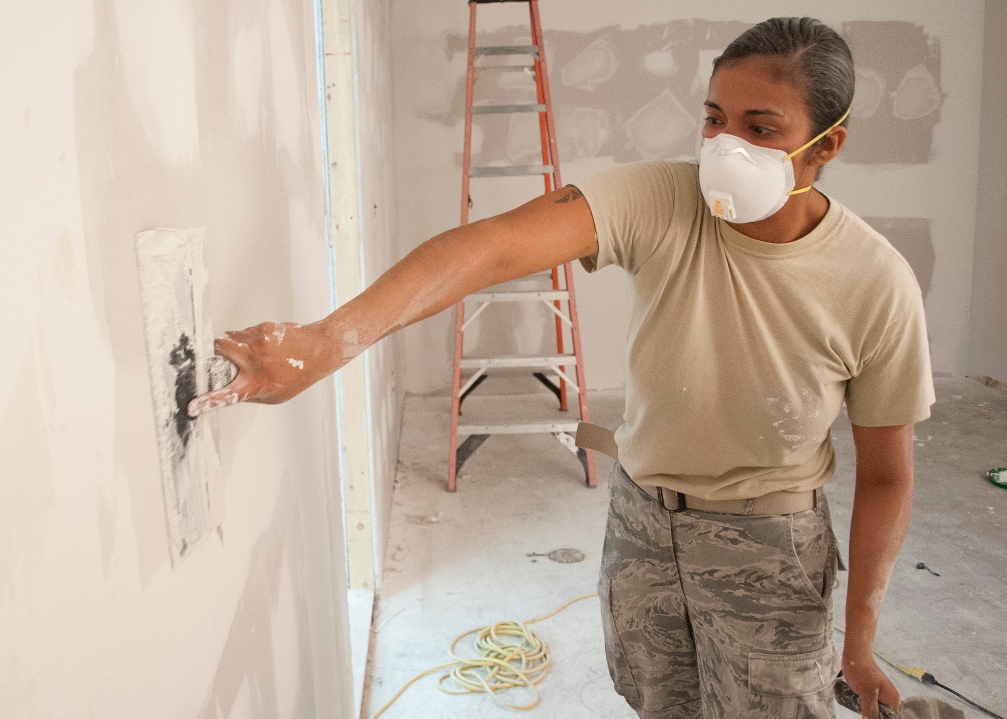 Senior Airman Laura Jauregui, 436th Civil Engineer Squadron structural journeyman, applies drywall clay June 25, 2014, on Dover Air Force Base, Del. The wall was created during renovations that took place to improve the Combat Arms Training and Maintenance building. (U.S. Air Force photo/Senior Airman Jared Duhon)