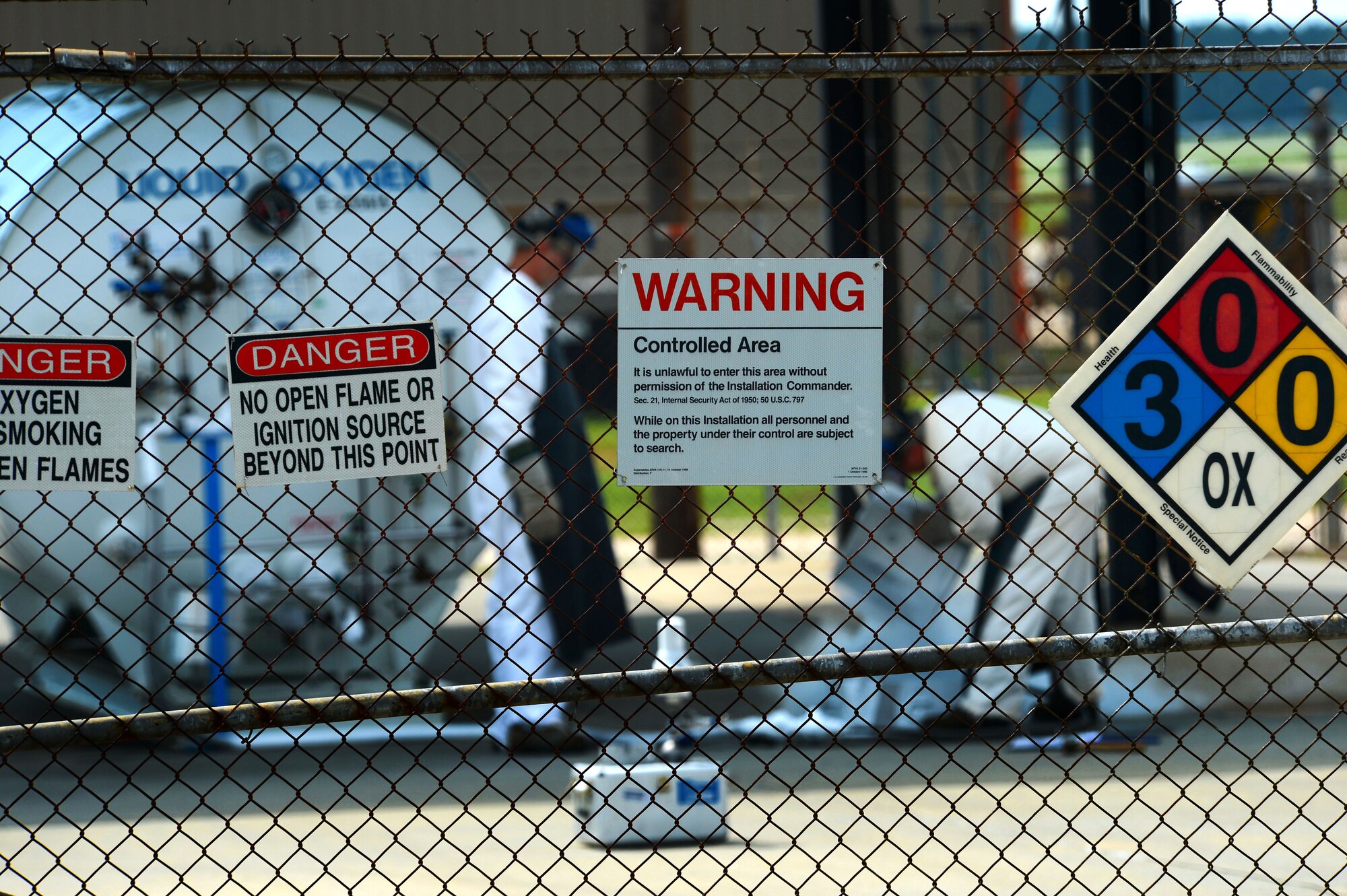 Warning signs hang on a perimeter fence surrounding a liquid oxygen tank at Shaw Air Force Base, S.C., June 26, 2014. The 1,738 gallon tank supplies the pilots of three F-16CJ Fighting Falcon squadrons here with pure oxygen while flying at high altitudes. (U.S. Air Force photo by Airman 1st Class Jensen Stidham/Released)