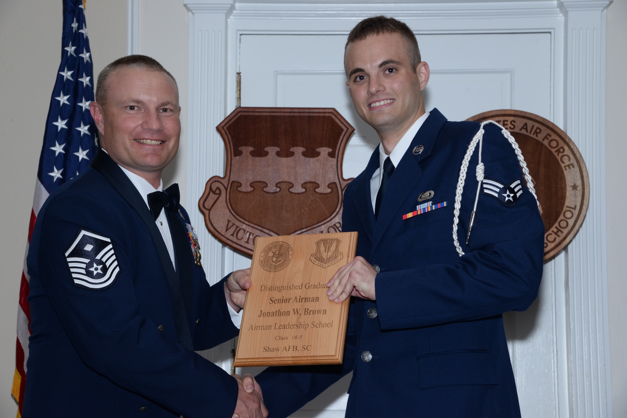 U.S. Air Force Senior Airman Jonathon Brown, 3rd Intelligence Squadron (right), receives one of the Senior Master Sgt. David B. Reid Airman Leadership School Class 14-5 distinguished graduate awards from Master Sgt. Gregory Spiczka, 20th Security Forces Squadron first sergeant during the class’ graduation at Shaw Air Force Base, S.C., June 26, 2014. These awards are given to the top 10 percent of Airmen in the class for total point accumulation. (U.S. Air Force photo by Airman 1st Class Jonathan Bass/Released)