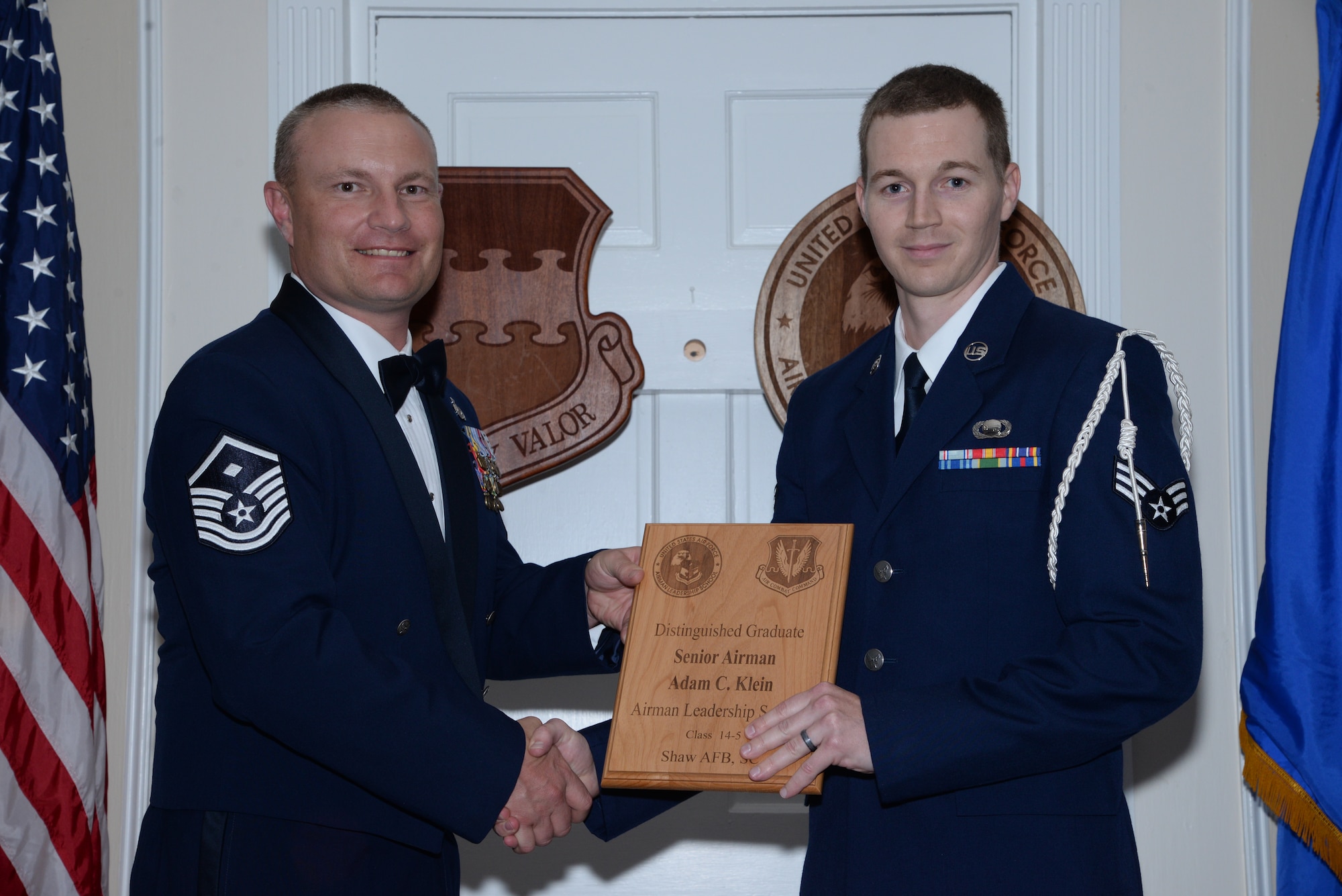 U.S. Air Force Staff Sgt. Zachary Taylor, 3rd Intelligence Squadron (right), receives one of the Senior Master Sgt. David B. Reid Airman Leadership School Class 14-5 distinguished graduate awards from Master Sgt. Gregory Spiczka, 20th Security Forces Squadron first sergeant during the class’ graduation at Shaw Air Force Base, S.C., June 26, 2014. These awards are given to the top 10 percent of Airmen in the class for total point accumulation. (U.S. Air Force photo by Airman 1st Class Jonathan Bass/Released)