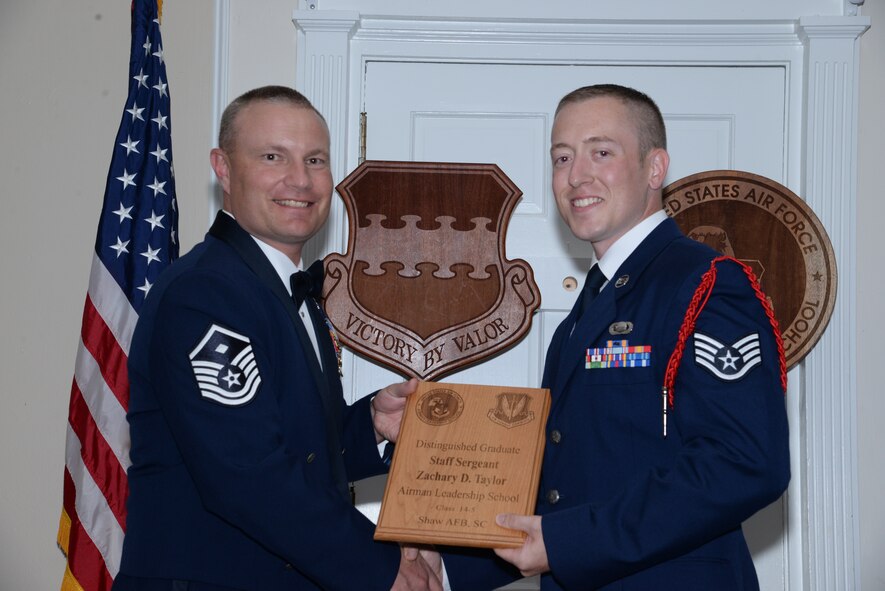 U.S. Air Force Staff Sgt. Zachary Taylor, 3rd Intelligence Squadron (right), receives one of the Senior Master Sgt. David B. Reid Airman Leadership School Class 14-5 distinguished graduate awards from Master Sgt. Gregory Spiczka, 20th Security Forces Squadron first sergeant during the class’ graduation at Shaw Air Force Base, S.C., June 26, 2014. These awards are given to the top 10 percent of Airmen in the class for total point accumulation. (U.S. Air Force photo by Airman 1st Class Jonathan Bass/Released)