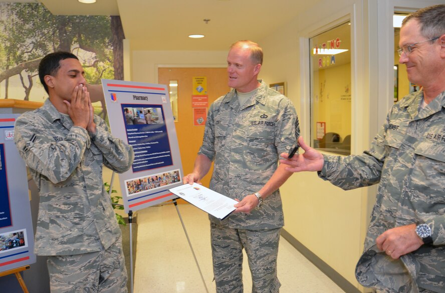 Airman First Class Jesse Charran-Sankar of the 78th Medical Group gasps when Chief Master Sgt. of the Air Force James Cody announces that he has been awarded senior airman below the zone and will be promoted six months in advance. Col. James H. Dienst, right, 78th MDG commander, uses Cody’s cell phone so Charran-Sankar’s mother could see her son’s reaction on a video chat. (U.S. Air Force photo/Staff Sgt. Kelly Goonan)