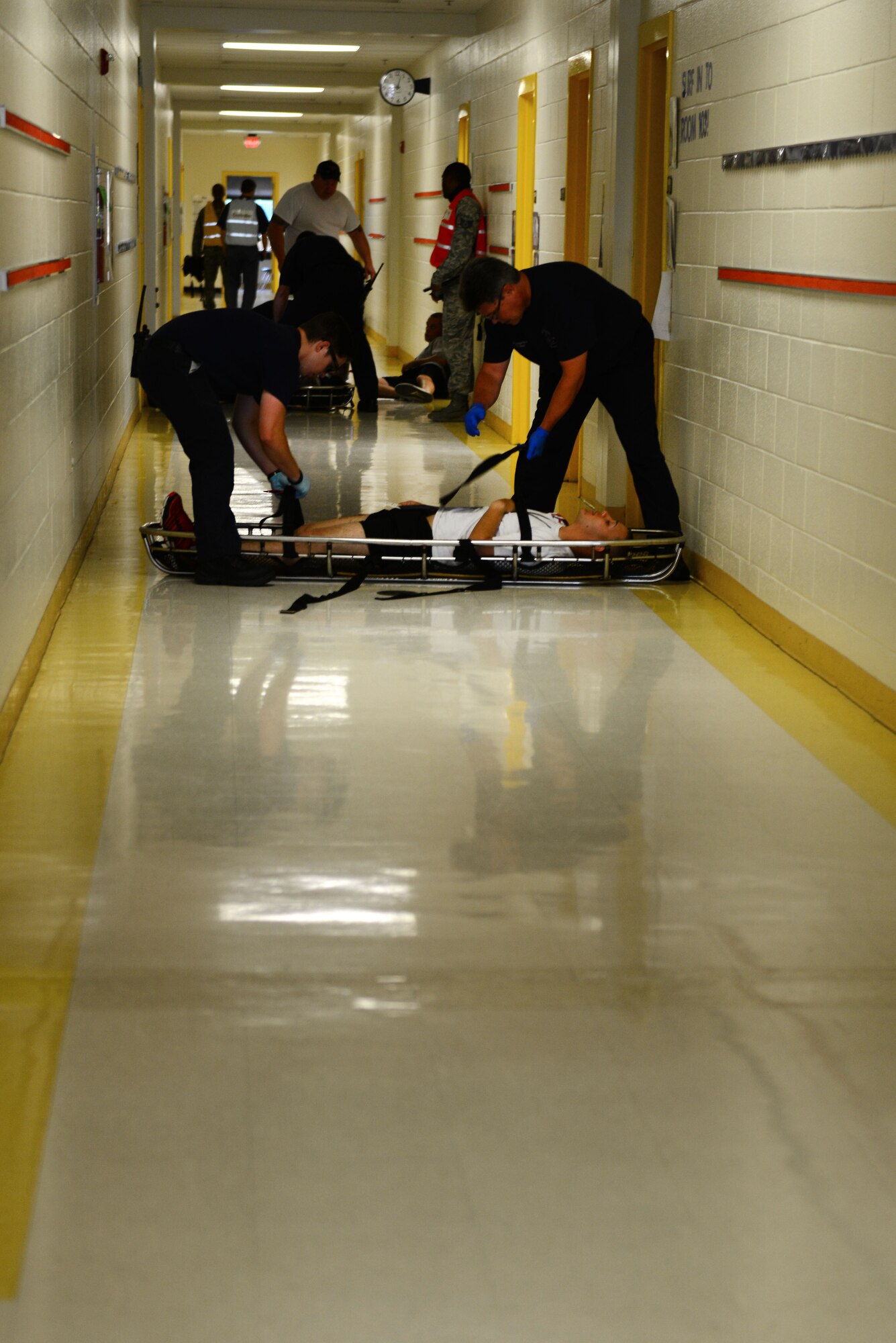 First responders gather the wounded during a simulated active shooter exercise at General Stanford elementary school located at Fort Eustis, Va., June 26, 2014. The exercise was used to test the 733rd Security Forces Squadron, the Fort Eustis first responders and the school administration. (U.S. Air Force photo by Airman 1st Class Kimberly Nagle/Released)