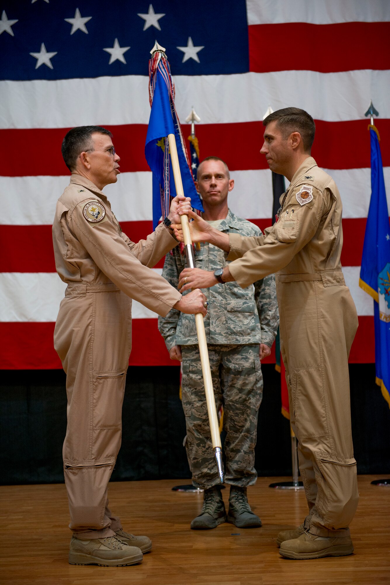 U.S. Air Force Col. John Klein hands the 386th Air Expeditionary Wing guidon to Brig. Gen. Timothy Frye, mobility forces director, during a formal change of command ceremony June 26, 2014 at an undisclosed location in Southwest Asia. Klein will be moving on to the Pentagon in Washington, District of Columbia to serve as the division chief of mobility requirements. (U.S. Air Force photo by Staff Sgt. Jeremy Bowcock)