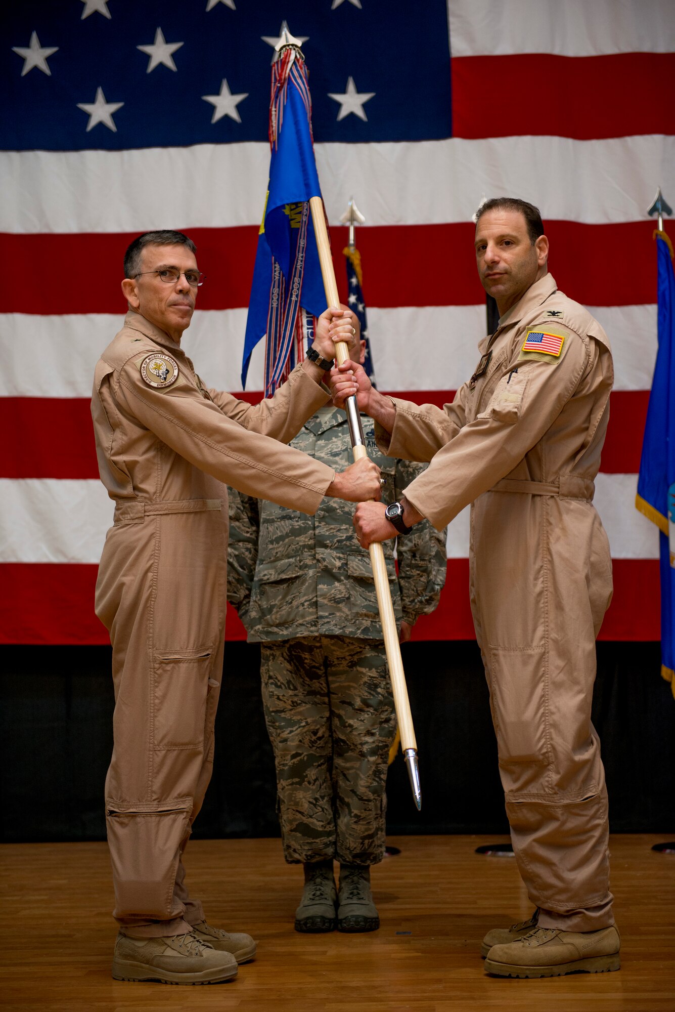 U.S. Air Force Brig. Gen. Timothy Frye, mobility forces director , hands the 386th Air Expeditionary Wing guidon to Col. Jason Hanover during a formal change of command ceremony June 26, 2014 at an undisclosed location in Southwest Asia. Hanover assumed command after serving as the military assistant to the commander, NATO Special Operations Headquarters, Supreme Headquarters Allied Powers Europe in Belgium. (U.S. Air Force photo by Staff Sgt. Jeremy Bowcock)