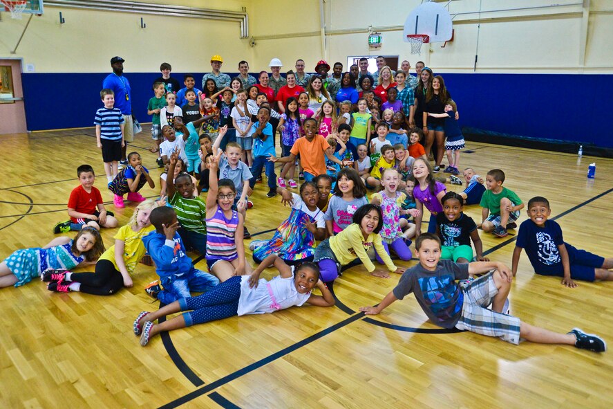 Children attending the 52nd Force Support Squadron’s School Age Program pose with Airmen from the 52nd Civil Engineer Squadron during the 52nd CES Career Day at the SAP building at Spangdahlem Air Base, Germany, June 18, 2014. SAP gives children of an opportunity to participate in various activities ranging from day camps to local field trips while enjoying their summer vacation from school. (U.S. Air Force photo by Staff Sgt. Joe W. McFadden//Released)