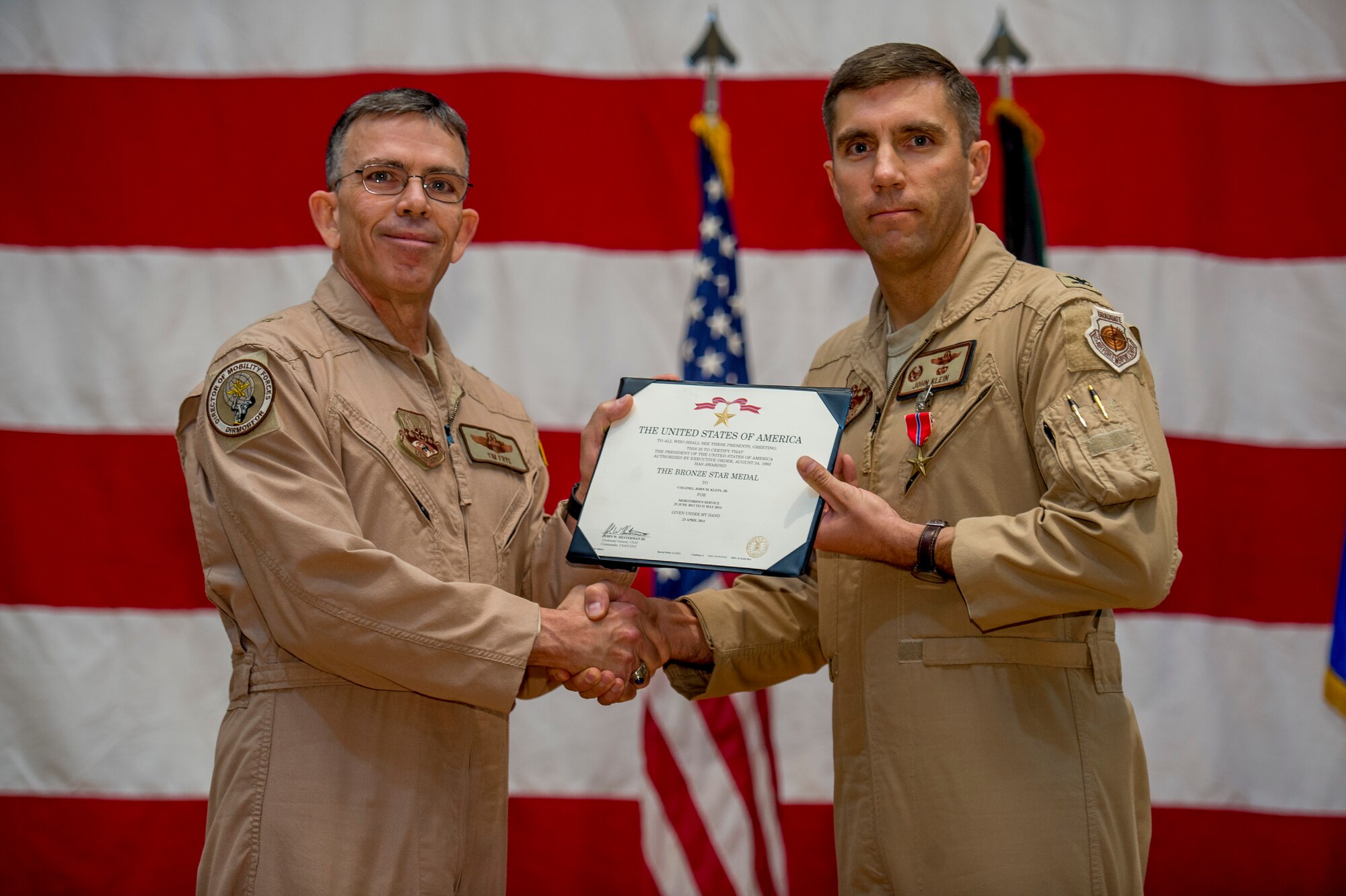 U.S. Air Force Brig. Gen. Timothy Frye, mobility forces director, presents Col. John Klein, 386th Air Expeditionary Wing commander, the Bronze Star June 26, 2014 at an undisclosed location in Southwest Asia. Klein was awarded the medal just before relinquishing command of the 386th AEW to Col. Jason Hanover during a formal change of command ceremony. (U.S. Air Force photo by Staff Sgt. Jeremy Bowcock)