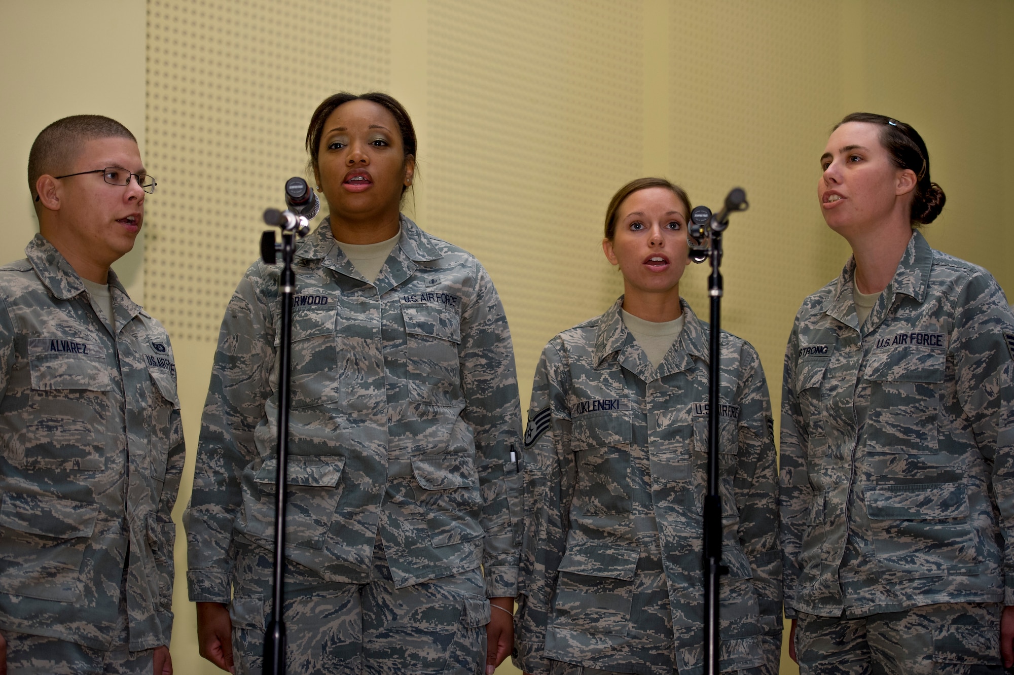 U.S. Air Force Staff Sgt. Iman Norwood, Claire Armstrong, Jennifer Kuklenski, and Senior Airman Gregory Alvarez, 386th Air Expeditionary Wing, sing the national anthem during a wing formal change of command ceremony June 26, 2014 at an undisclosed location in Southwest Asia. (U.S. Air Force photo by Staff Sgt. Jeremy Bowcock)