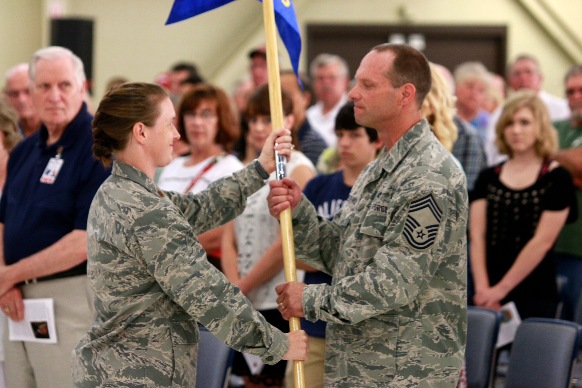 Maj. Sara Stigler hands her squadron guidon to Chief Master Sgt. Donnie Frederick following her assumption of command of the newly activated 153rd Intelligence Squadron during a Conversion Day ceremony held at Ebbing Air National Guard Base, Fort Smith, Arkansas, June 7, 2014.  The ceremony also recognized the many changes occurring at the wing as a result of its conversion to a remotely piloted aircraft (MQ-9 Reapers) and ISR mission. The 188th Fighter Wing was redesignated as the 188th Wing during the event as well. (U.S. Air National Guard photo by Staff Sgt. Matt Pelkey)