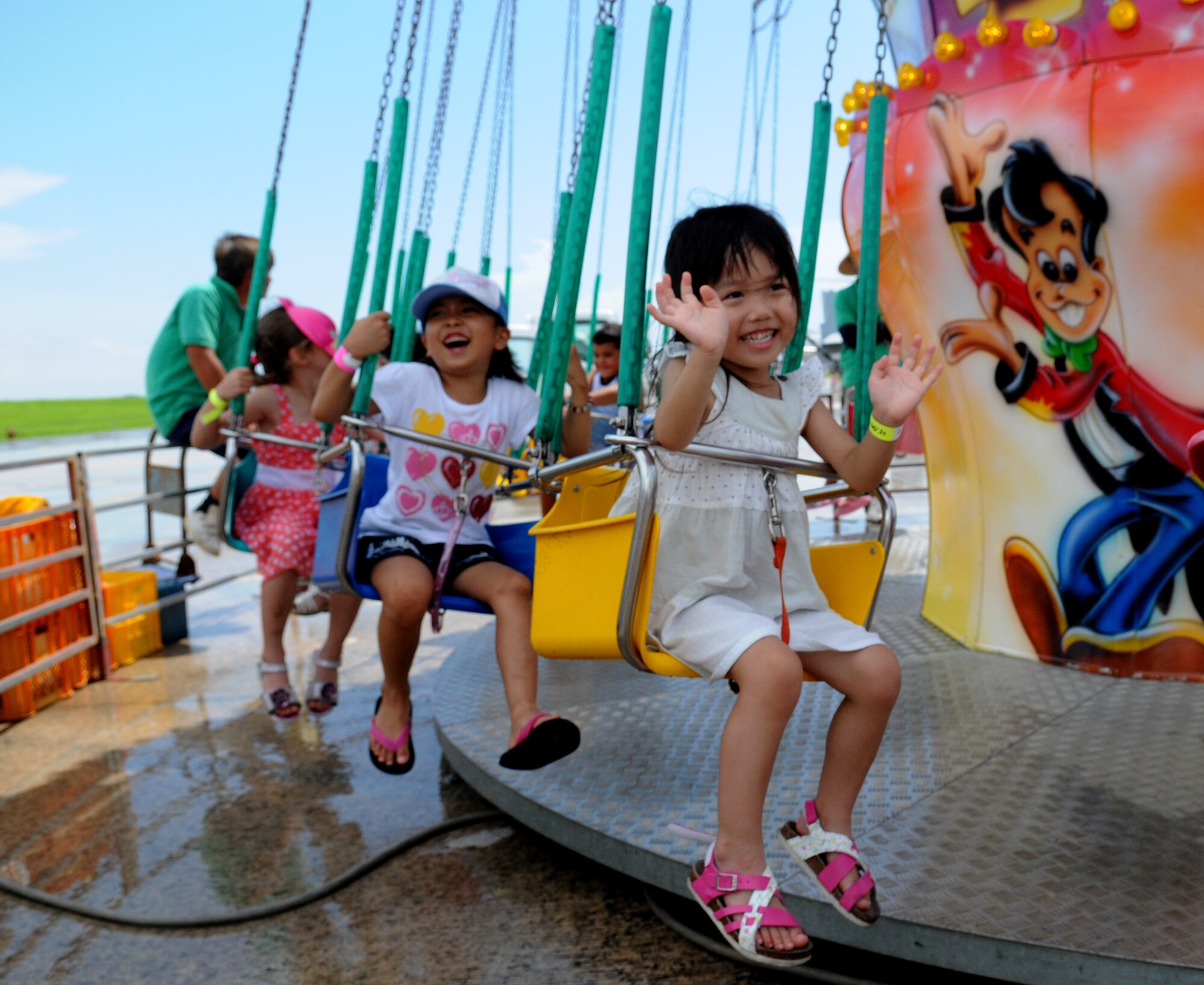 Local children ride the carnival swing during America Fest 2014 at Kadena Air Base, Japan, June 29. America Fest is a two-day event which allows the local Okinawan population and military members from around Okinawa to experience a Fourth of July celebration through activities such as music, carnival rides, aircraft static displays and fireworks. (U.S. Air Force photo by Airman 1st Class Keith James)