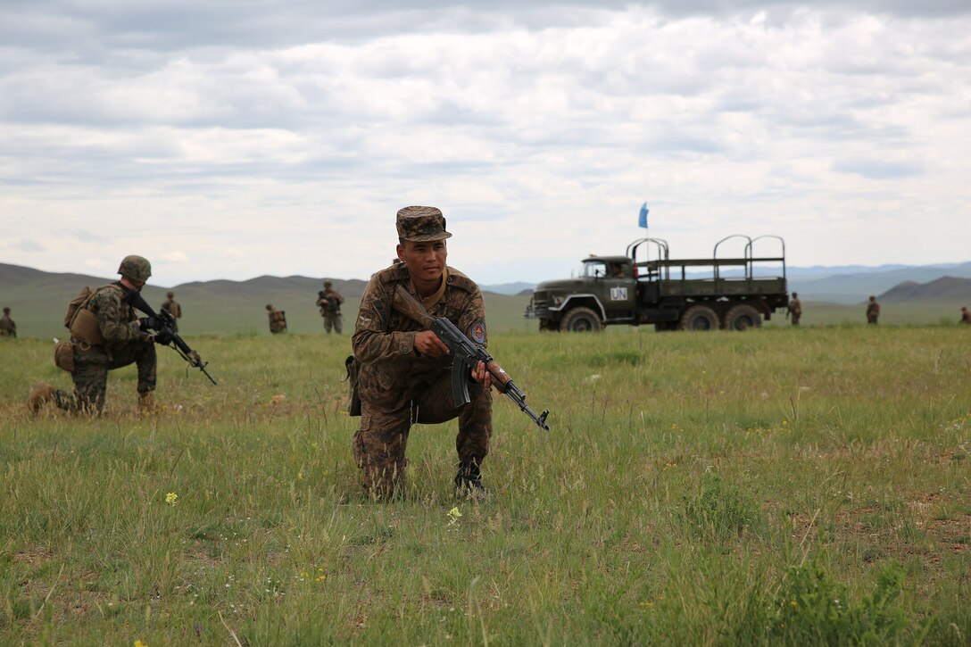 Mongolian Armed Forces members and U.S. Marines and sailors provide security for a simulated improvised explosive device drill June 23 at Five Hills Training Area, Mongolia, during convoy operations training at Exercise Khaan Quest 2014. KQ14 is a regularly scheduled, multinational exercise hosted annually by Mongolian Armed Forces and co-sponsored this year by U.S. Army, Pacific and U.S. Marine Corps Forces, Pacific. KQ14 is the latest in a continuing series of exercises designed to promote regional peace and security. This year marks the 12th iteration of this training event. During the training, the service members searched for simulated improvised explosive devices and then practiced what they would do in a real-world situation. The Marines and sailors are with Company C, 1st Battalion, 8th Marine Regiment, which is currently assigned to 4th Marine Regiment, 3rd Marine Division, III Marine Expeditionary Force, under the unit deployment program. (U.S. Marine Corps photo by Cpl. Alyssa N. Gunton)