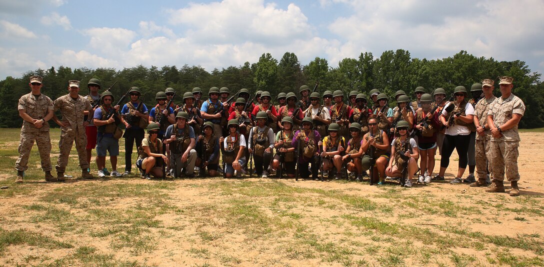 Marines from The Basic School and guests of the Educators and Key Leaders Workshop pose after patrolling open roads in Quantico, VA., June 26, 2014. Newly commissioned officers arrive to The Basic School upon completion of OCS to be trained to lead as provisional infantry platoon leaders in the operational forces. Guests learn basic fire team maneuvers, combat lifesaving skills and patrol open dirt roads at TBS. The Educators and Key Leaders Workshop exposes college professors and community leaders to the myriad career opportunities the Marine Corps offers, specifically geared toward officer commissioning programs