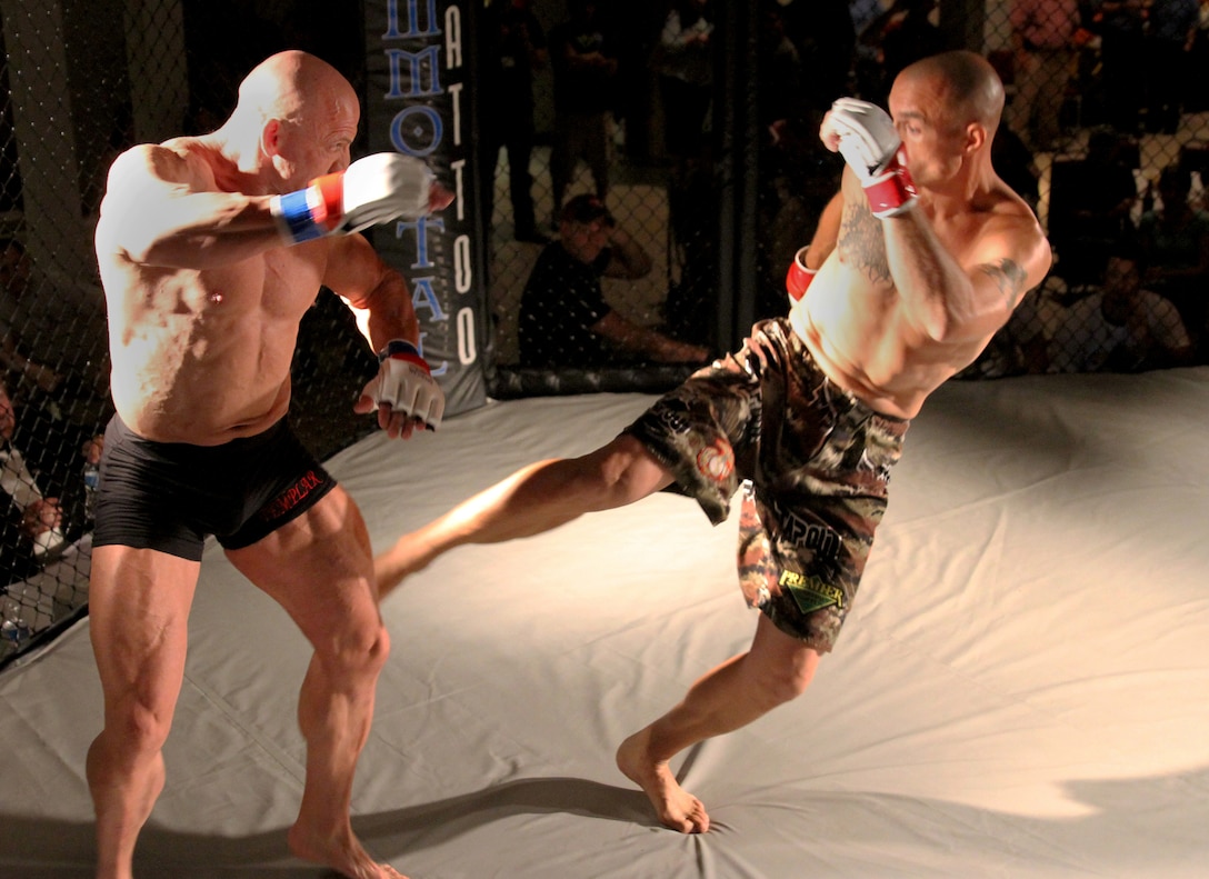 Master Sgt. Donald W. Johnson, right, a low altitude air defense gunner with Marine Air Control Group 28, attached to Marine Medium Tiltrotor Squadron 365 (Reinforced), 24th Marine Expeditionary Unit, and native of Rush City, Minn., lands a kick on his opponent’s leg during a mixed martial arts fight in Havelock, N.C., June 21, 2014. Johnson won by knockout in 48 seconds and advanced his record to 2-0. He is scheduled to deploy with the 24th MEU at the end of the year. (U.S. Marine Corps by Lance Cpl. Austin A. Lewis)