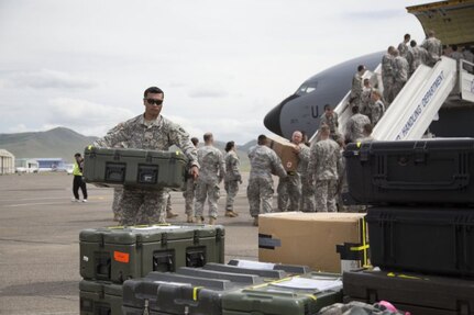 Alaska Army National Guard Sgt. Edsel Huynh, 297th Battlefield Surveillance Brigade, carries medical supplies off a 168th Air Refueling Wing KC-135, after arriving in Ulaanbaatar, Mongolia, June 16, 2014. Approximately 100 Alaska Guard members are participating in Exercise Khaan Quest 2014, a multinational training exercise designed to strengthen the capabilities of U.S., Mongolian and other partner nations for effective participation in international peace support operations worldwide.