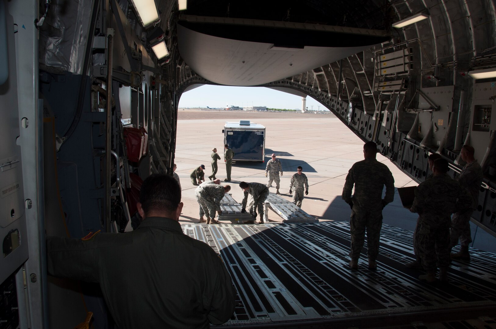 Members of the Arizona National Guard's 91st Civil Support Team and the Air Force Reserve's 729th Airlift Squadron construct loading ramps on the cargo bay door of a C-17A Globemaster III during a static load training exercise at Williams Gateway Airport in Mesa, Ariz. The two units worked together to enhance the rapid deployment capability of the Arizona's weapons of mass destruction response force June 24. 