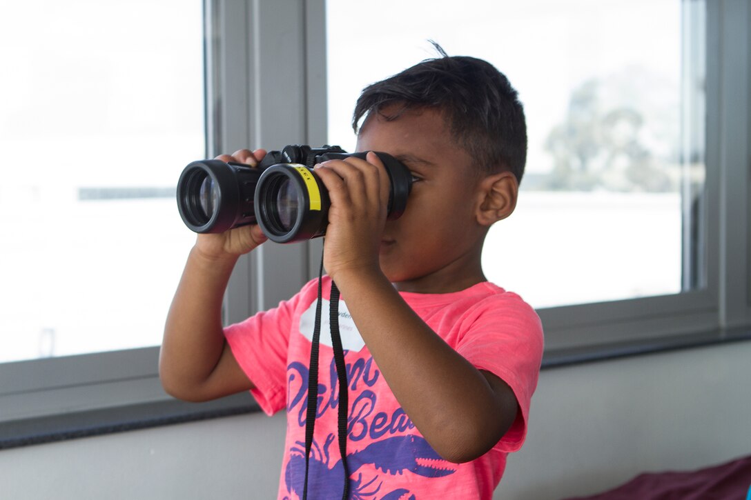 Jaden Brown, 5, takes a look at the flight line from the Aircraft Rescue and Firefighting building during a Lil’ Leatherneck Day aboard Marine Corps Air Station Miramar, Calif., June 27. Headquarters and Headquarters Squadron hosted the event as an opportunity for military children to understand what their parents do as Marines and Sailors.
