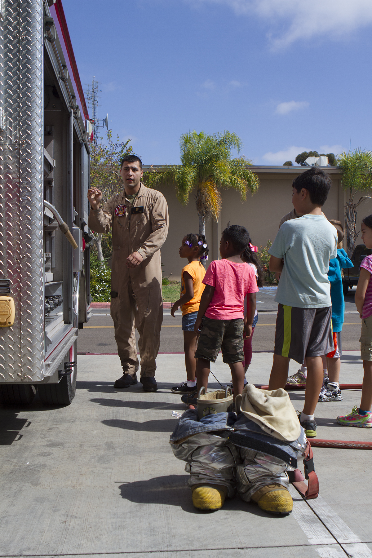 Pfc. Sergio Guillen, a rescueman with Aircraft Rescue and Firefighting, shows off tools on a fire truck during a Lil’ Leatherneck Day aboard Marine Corps Air Station Miramar, Calif., June 27. The Headquarters and Headquarters Squadron event promoted understanding between military families and the military lifestyle in an interactive way.