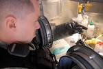 Army Staff Sgt. Aaron Zuniga, a science and healthcare specialist assigned to the 95th Civil Support Team, California Army National Guard, refers to his instructional steps before beginning to extract and test DNA from samples of a potential Weapon of Mass Destruction taken from a simulated domestic terrorist lab while participating in Operation Red Snow, Feb. 16, 2012 at the U.S. Marine Corps Mountain Warfare Training Center near Bridgeport, Calif. Operation Red Snow is a multi-agency chemical, biological, radiological and nuclear threat response exercise to strengthen the partnership between federal, state and local jurisdiction regarding a response to the possible threat of a domestic attack on the United States.